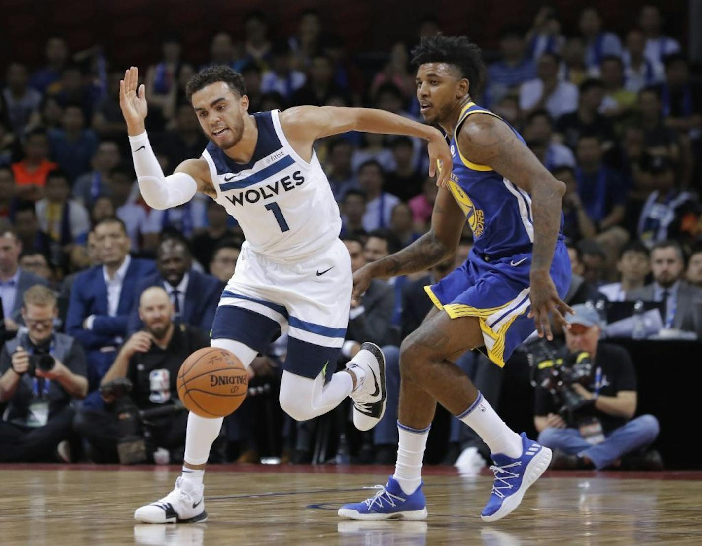 Minnesota Timberwolves' Tyus Jones, left drives past Golden State Warriors' Nick Young during the basketball match of the 2017 NBA Global Games in Shenzhen, south China's Guangdong province, Thursday, Oct. 5, 2017.