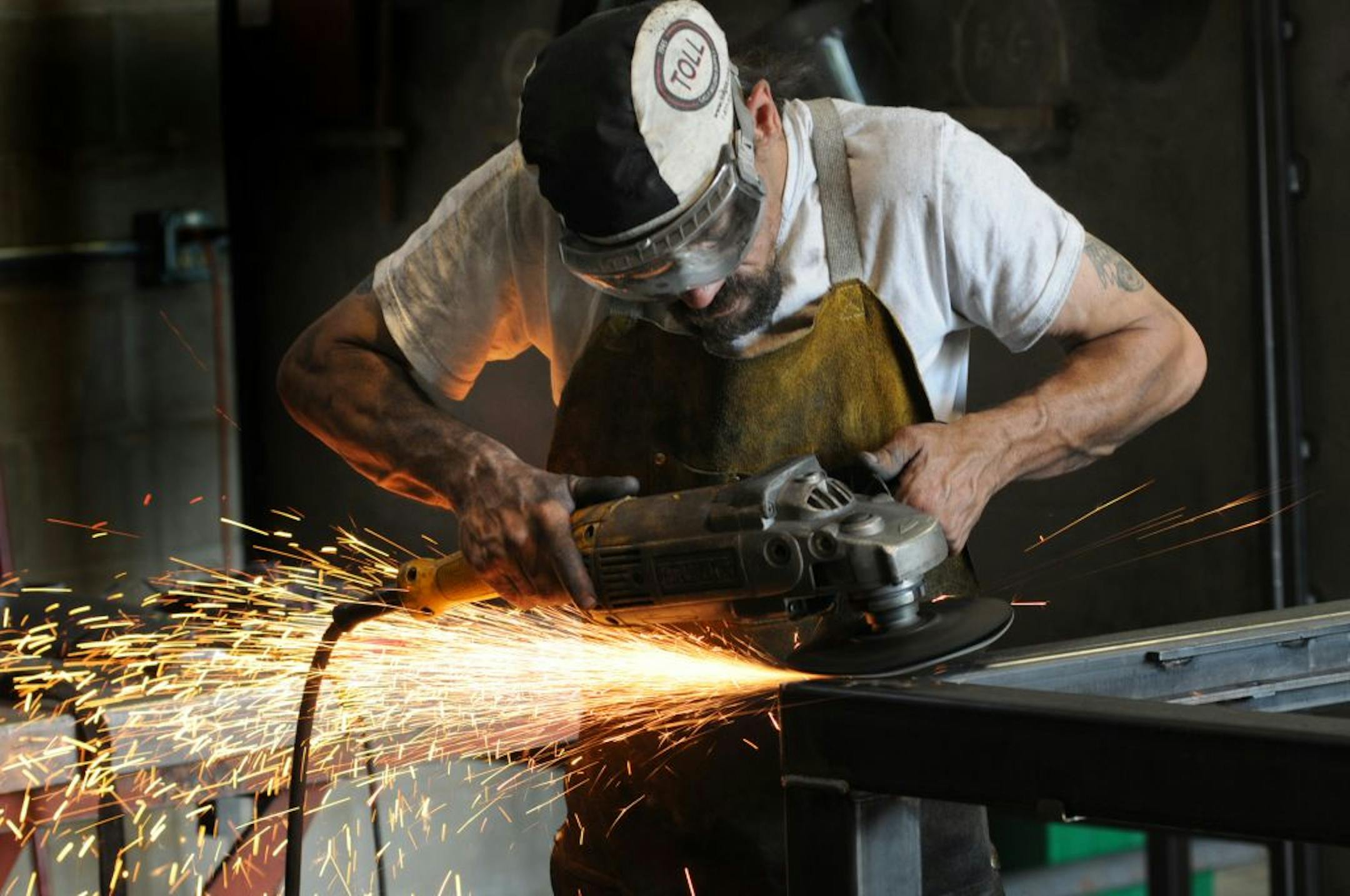 Mark Dauer uses a grinder on a welding project at Code Welding in Blaine, Minn.