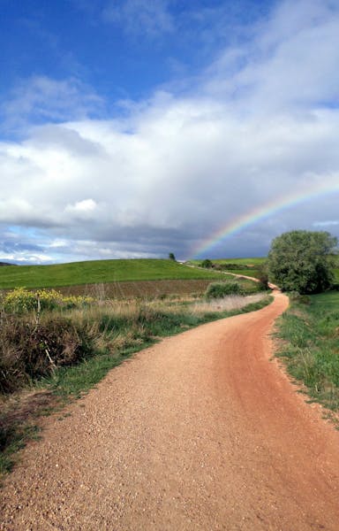 A rainbow beckons down the path of the Alto de Perdon (Mount of Forgiveness) along the Camino de Santiago in Spain. The popularity of walking &#x201c;