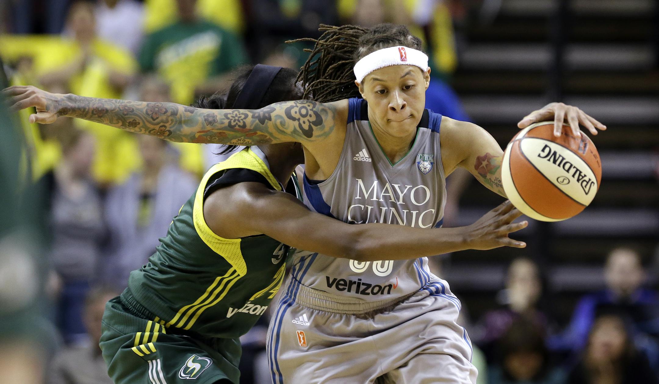 Seattle Storm's Jewell Loyd, left, fouls Minnesota Lynx's Seimone Augustus late in the second half of a WNBA basketball game Sunday, May 22, 2016, in Seattle. The Lynx won 78-71. (AP Photo/Elaine Thompson)