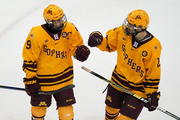 Gophers defenseman Ryan Johnson (23) congratulated forward Sammy Walker (9) after he scored on an empty net late in the third period. ] ANTHONY SOUFFL