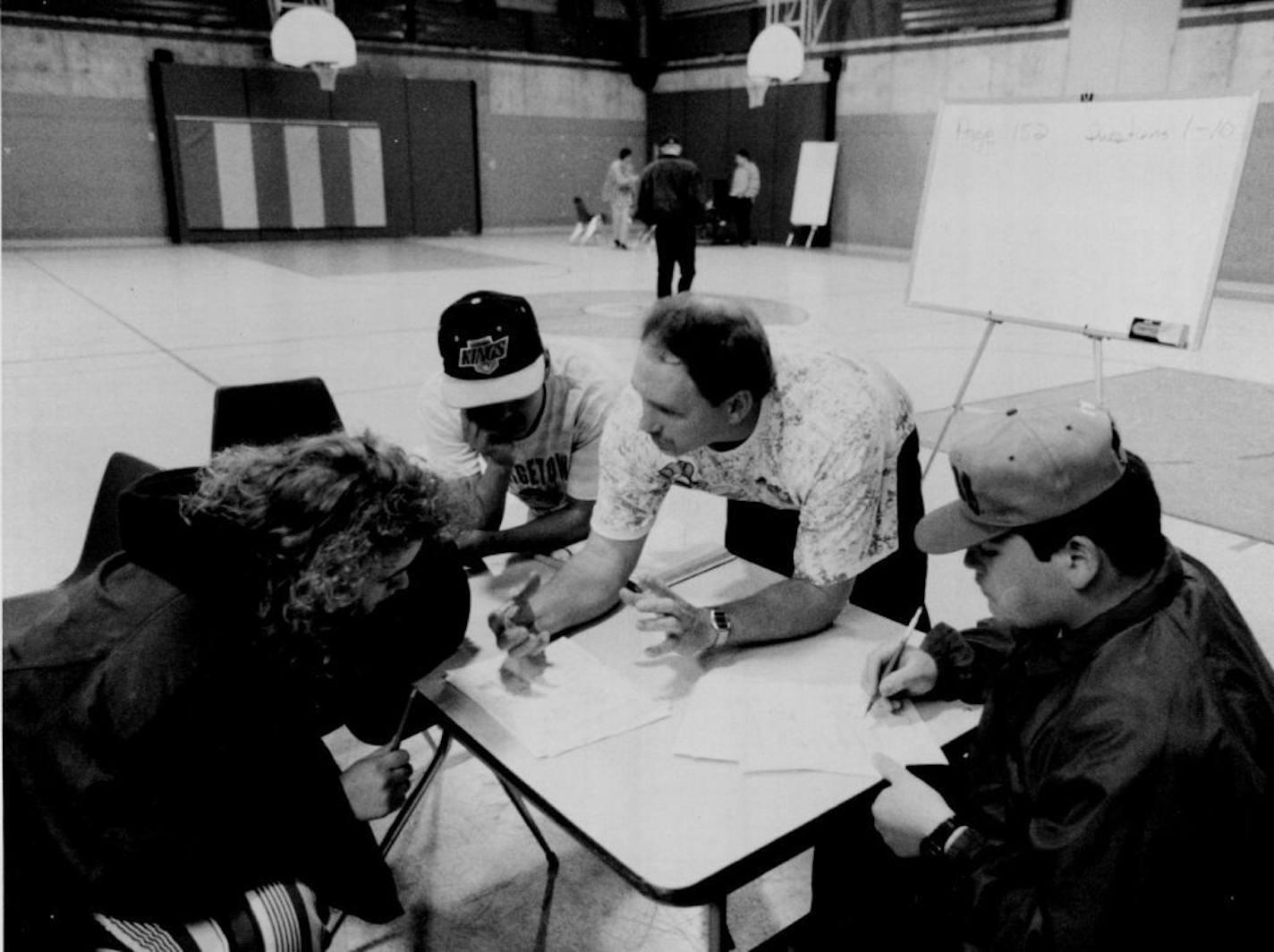 April 19, 1993 City Academy, Minnesota's first charter school. Terry Kraabel, second from right, conducted a class in nutrition in the recreation center gymnasium while another class, background was in session. Kraabel, one of the originating teachers, huddled with students Melinda Sjoblom, Reuben Paramo and Cipriano Ibarra.