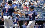 Minnesota Twins designated hitter Joe Mauer (7) greets teammate Brian Dozier (2) after scoring on Dozier's two-run home run during the sixth inning of
