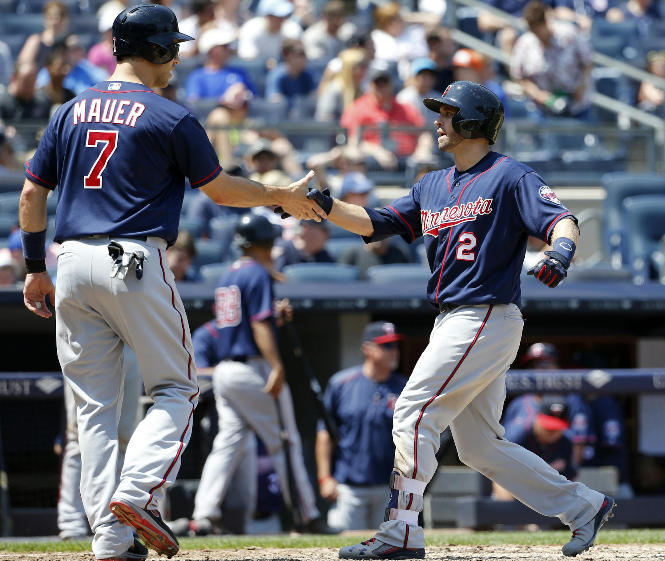 Minnesota Twins designated hitter Joe Mauer (7) greets teammate Brian Dozier (2) after scoring on Dozier's two-run home run during the sixth inning of a baseball game against the New York Yankees in New York, Sunday, June 26, 2016. (AP Photo/Kathy Willens)