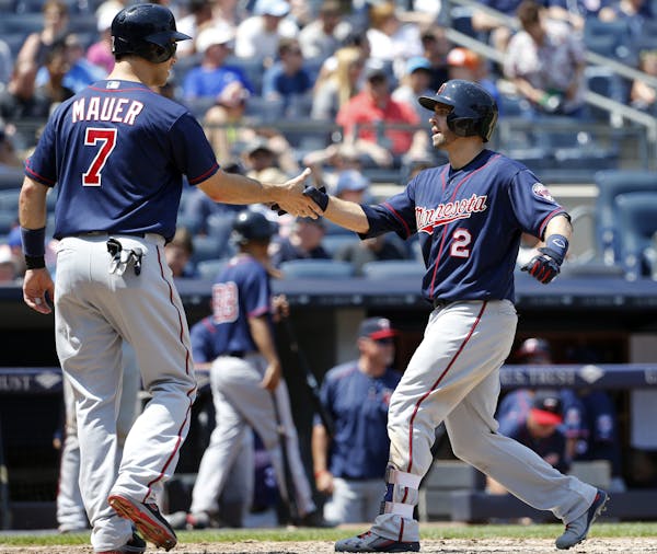 Minnesota Twins designated hitter Joe Mauer (7) greets teammate Brian Dozier (2) after scoring on Dozier's two-run home run during the sixth inning of