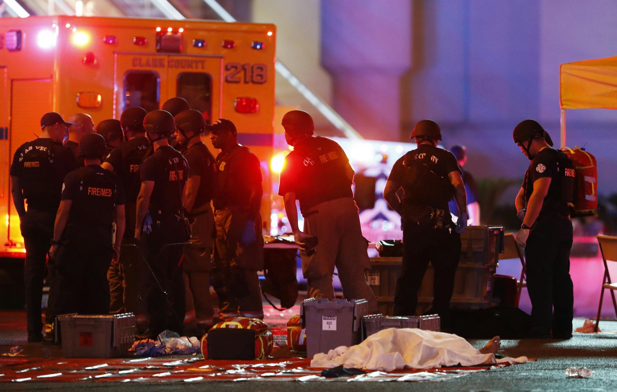 A body is covered with a sheet after a mass shooting in which dozens were killed at a music festival on the Las Vegas Strip on Sunday, Oct. 1, 2017.