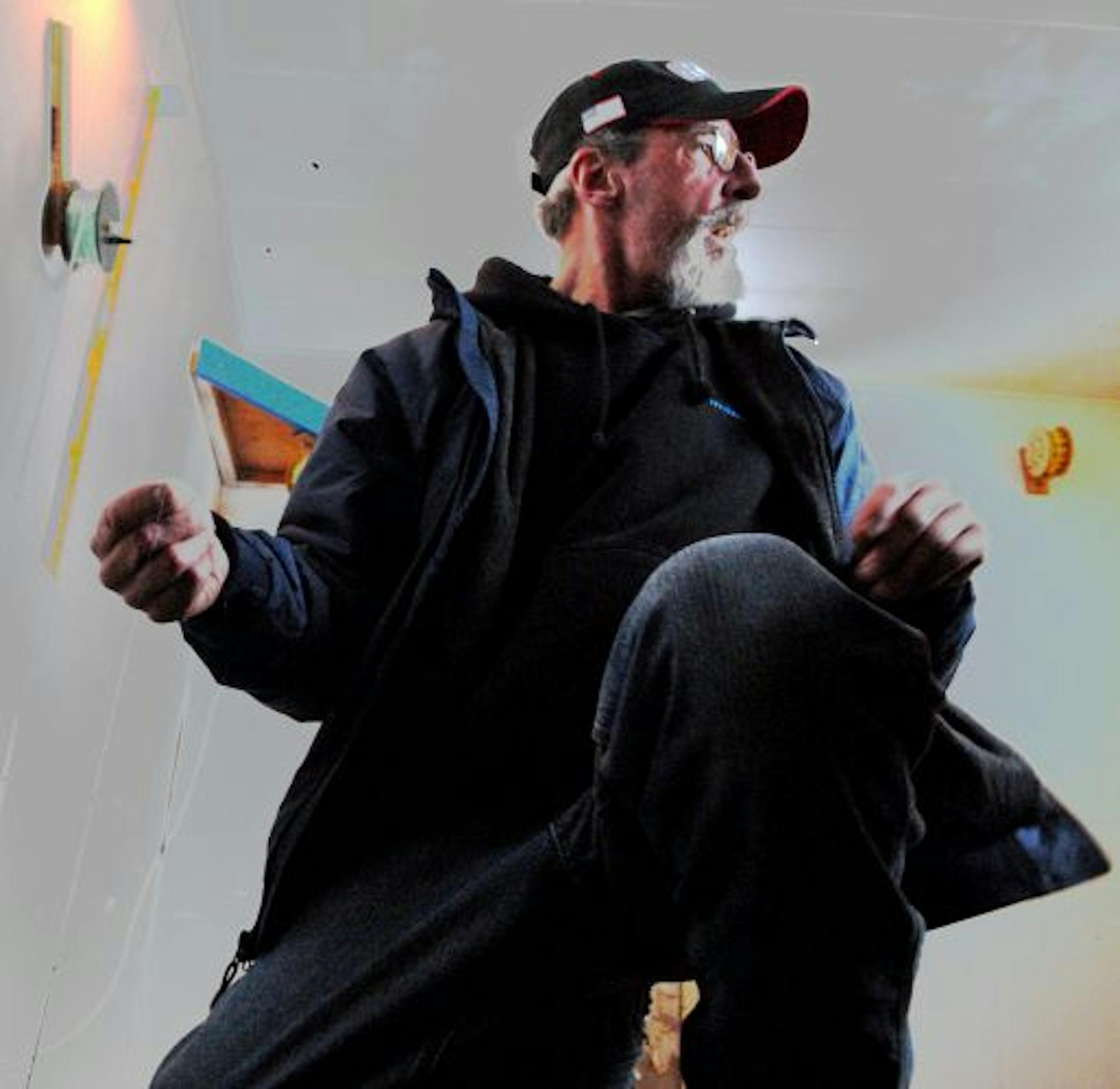 Spider Johnson lowered a line into Upper Red Lake, unfurling it from a rattle wheel in a fish house.