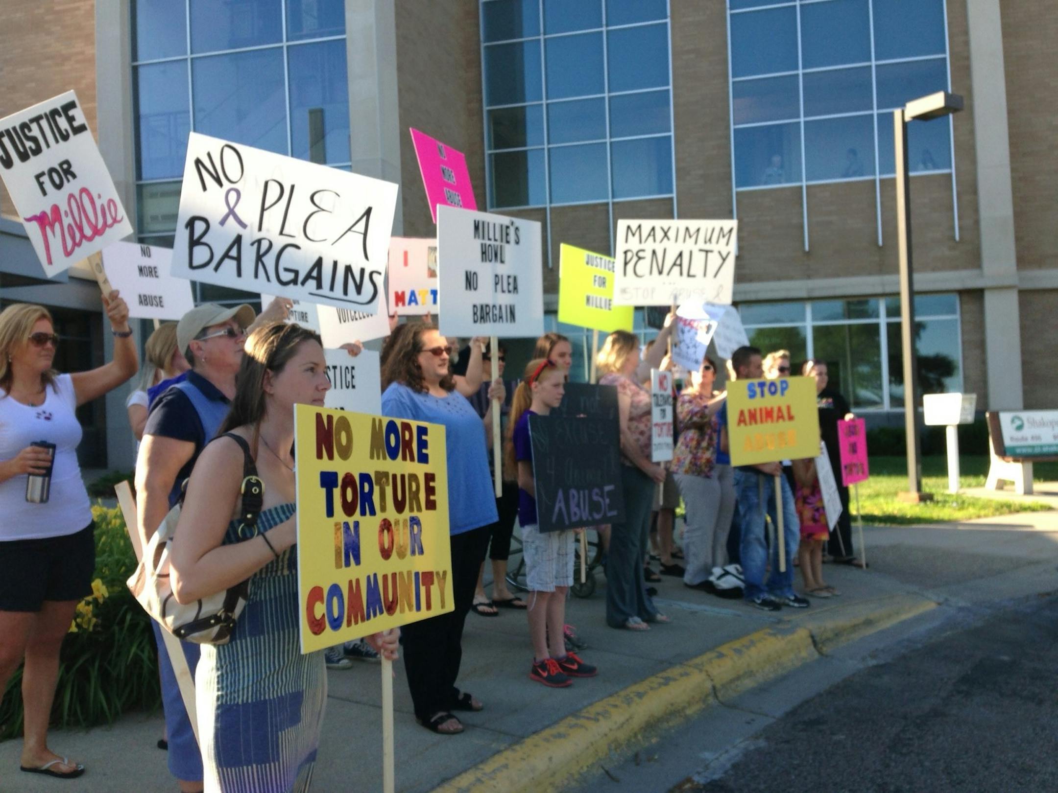 Protestors gathered outside the Scott County Courthouse in Shakopee on Friday as Rudolph Poppe made his first court appearance. He is charged with two counts of felony cruelty to animals for allegedly hitting his golden retriever over the head with a sledgehammer, crushing its skull.