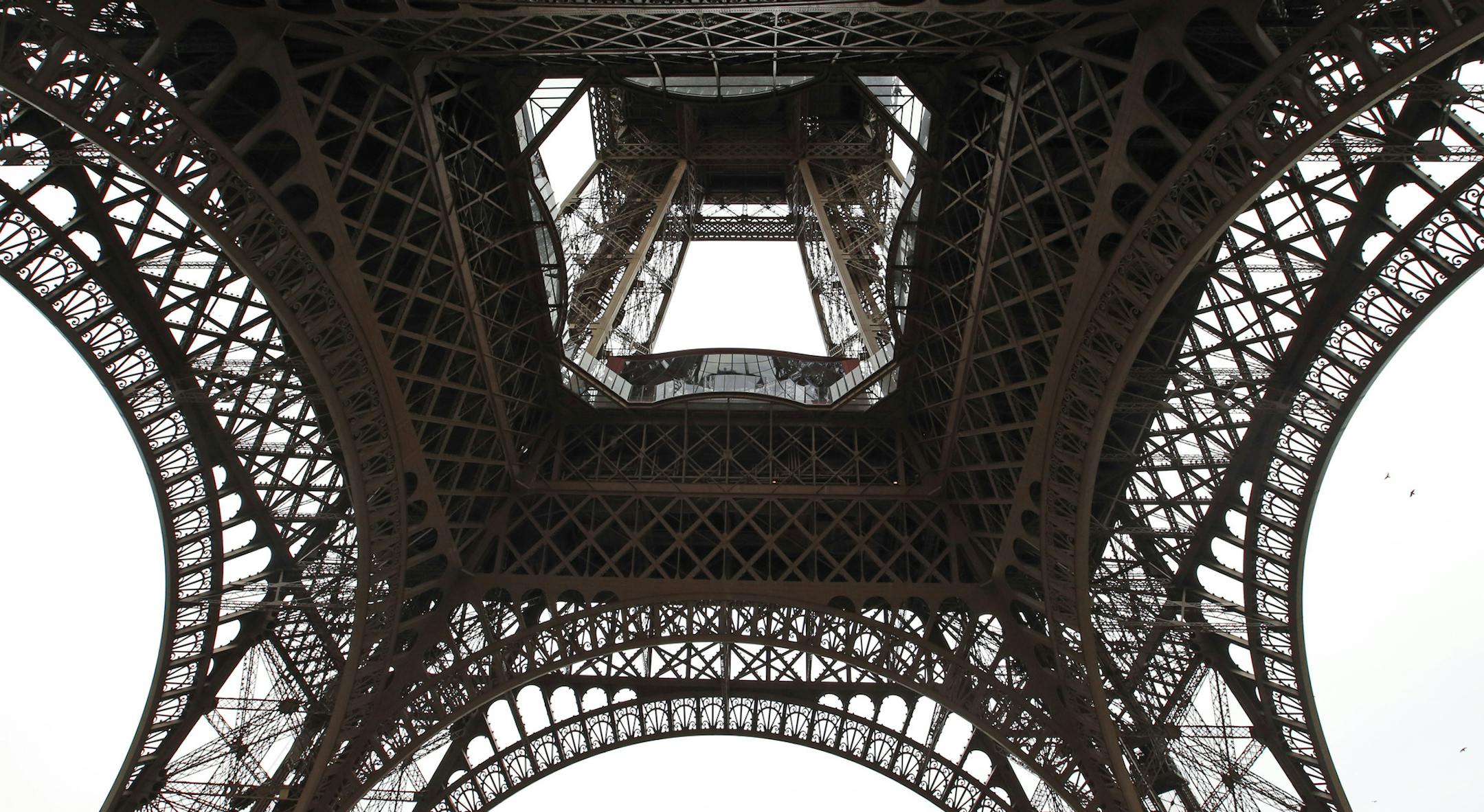 A general view looking up at the new glass floor at The Eiffel Tower during the inauguration of the newly refurbish first floor, in Paris, France, Monday, Oct. 6, 2014. The 324-meter (1,063-foot) Eiffel Tower has see-through glass floor panels on its first level, which is 57 meters (187 feet) high. The four small viewing sections, which cost 30 million euro ($38 million), were unveiled to visitors Monday. (AP Photo/Francois Mori)
