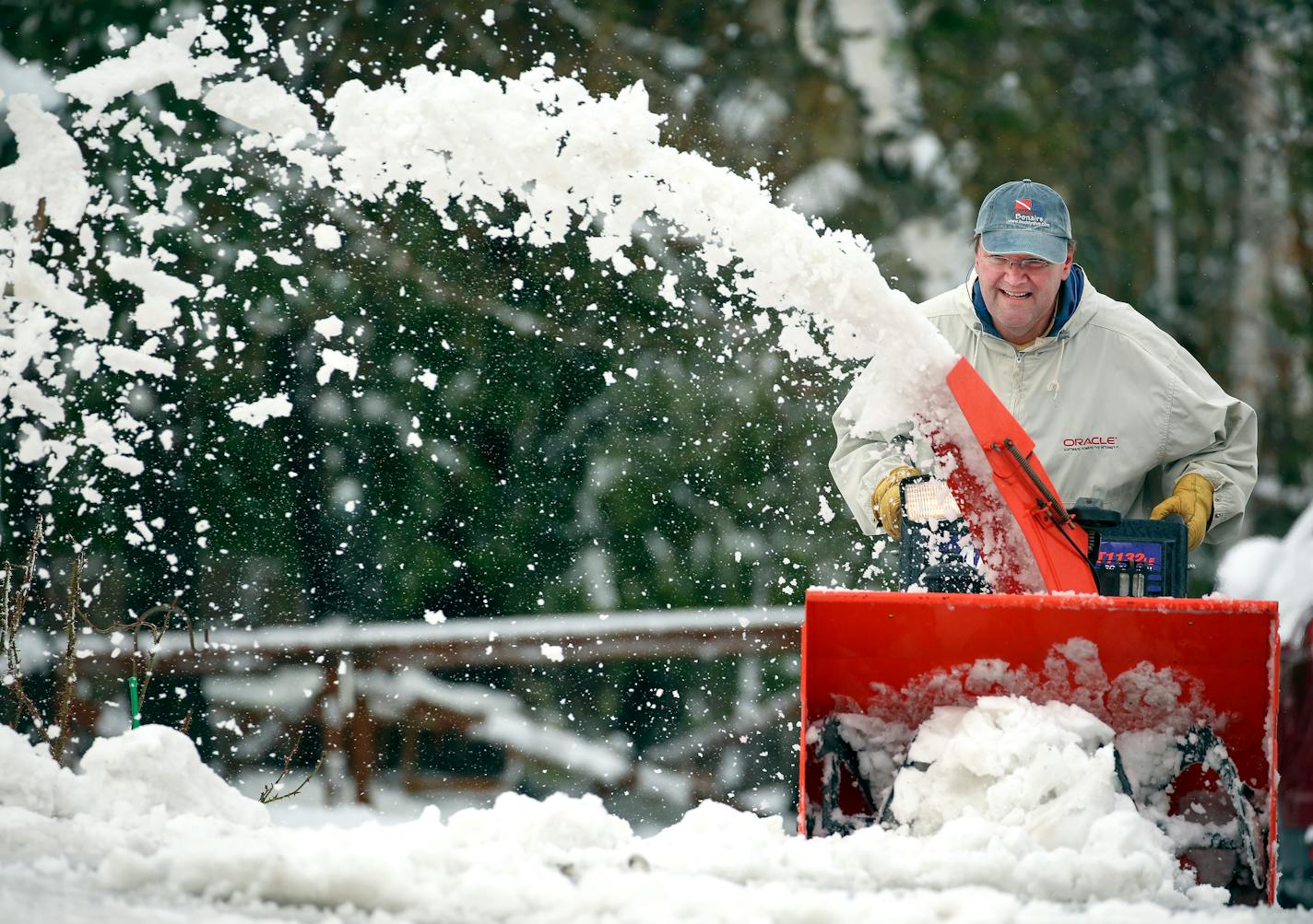 Tim Perala clears a neighbor's driveway along Rice Lake Road in Duluth Thursday morning. "I put all my shovels away, but not this," he said, gesturing toward his snowblower.