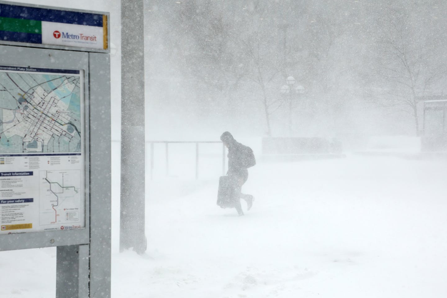 A traveler fought through the snow and ice to get to the Government Center light-rail station as the snow picked up Saturday in downtown Minneapolis.