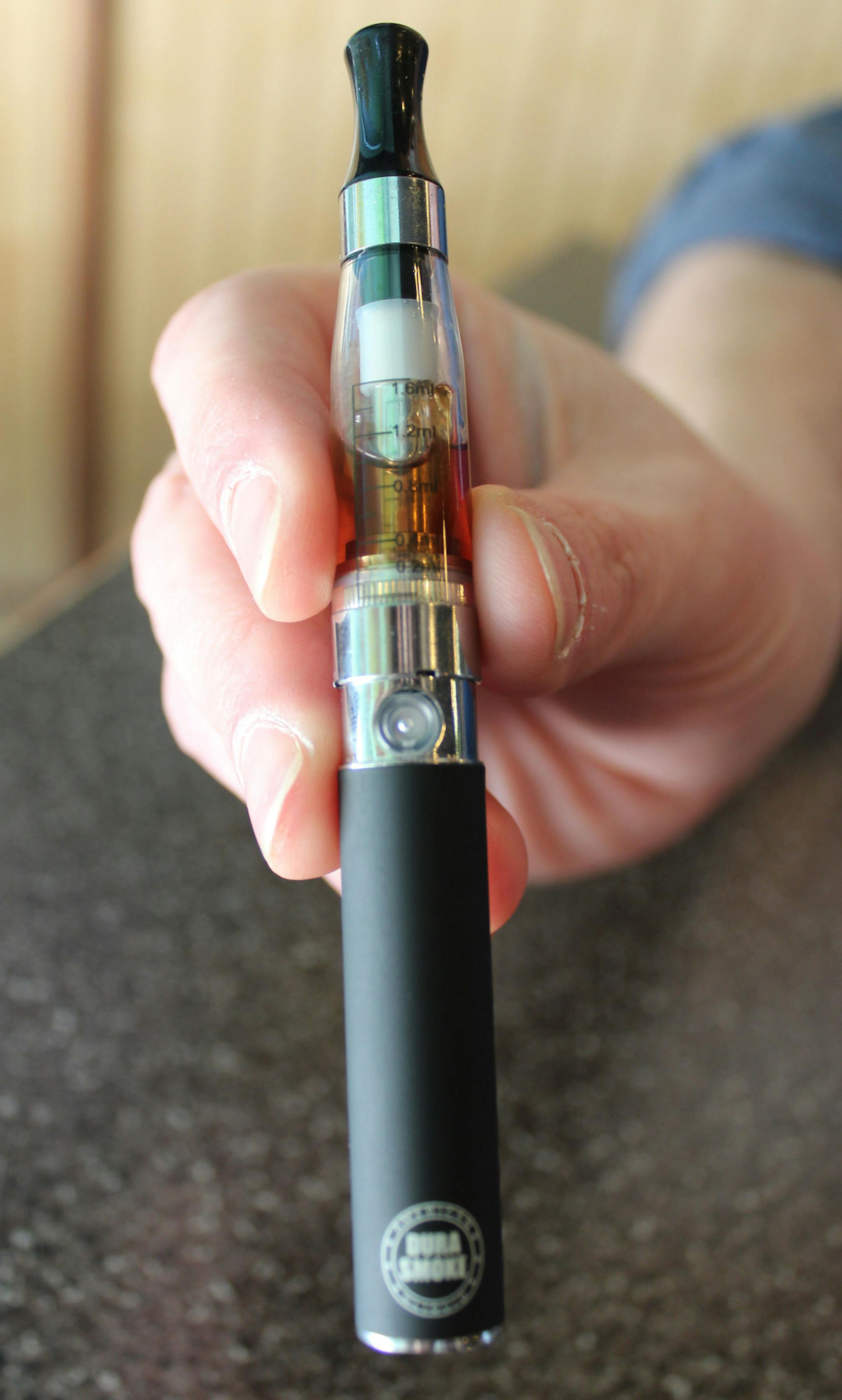 In this March 7, 2014 file photo, Lance McNally, 39, holds an electronic cigarette that contains a nicotine liquid which is heated by a rechargeable battery to produce vapors in Lansing, Mich. The Utah Department of Health says new survey data shows a significant increase in electronic cigarettes use among both adults and teenagers. A spokesman for the department say liquid nicotineís candy flavors can be more attractive to young people than traditional cigarettes, but using the devices can