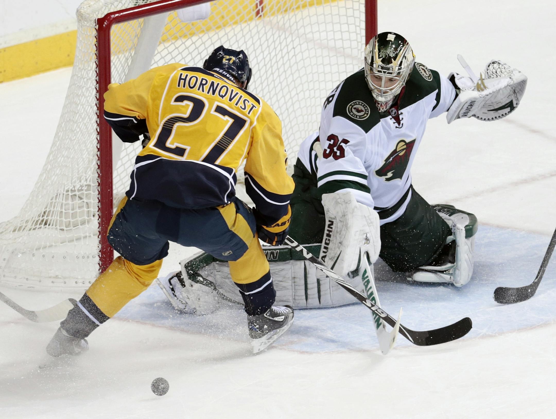 Minnesota Wild goalie Darcy Kuemper (35) blocks a shot by Nashville Predators forward Patric Hornqvist (27), of Sweden, in the second period of an NHL hockey game on Sunday, Jan. 12, 2014, in Nashville, Tenn.