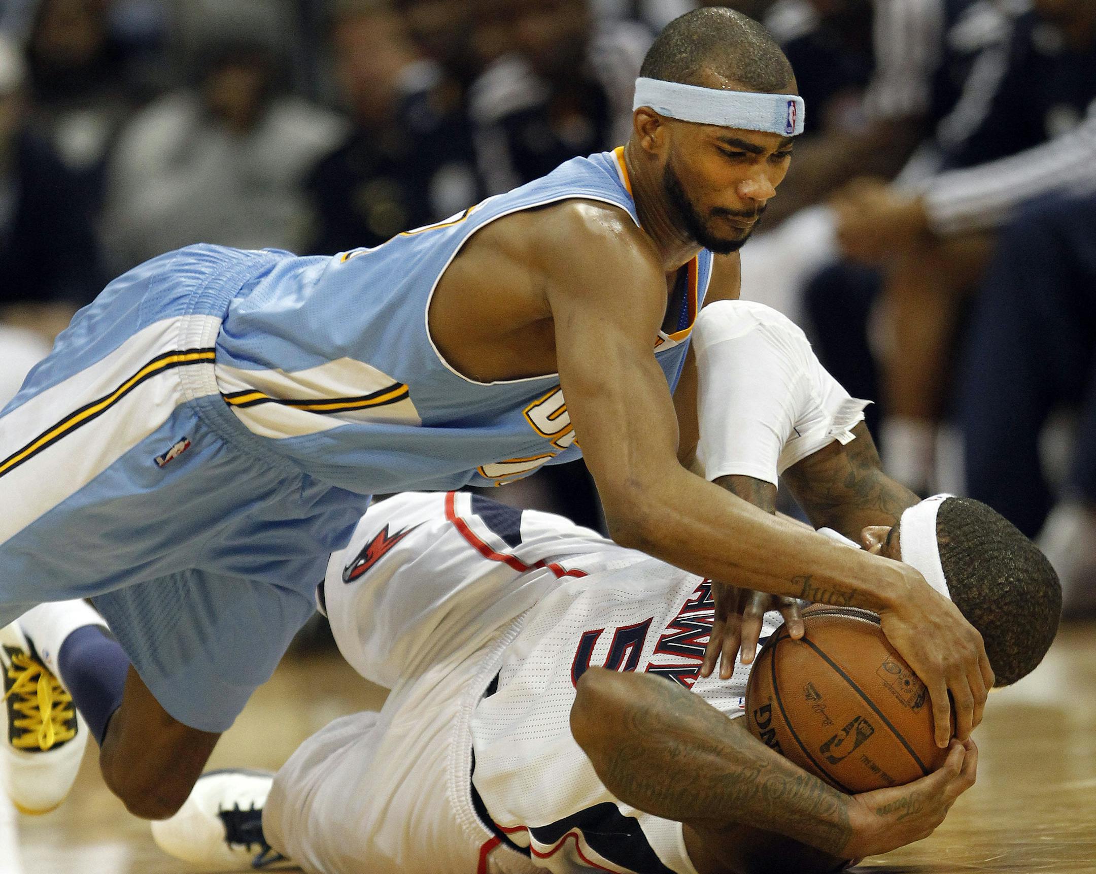 Denver Nuggets small forward Corey Brewer, top, and Atlanta Hawks small forward Josh Smith (5) scramble for a loose ball during the second half of an NBA basketball game on Wednesday, Dec. 5, 2012, in Atlanta. (AP Photo/John Bazemore) ORG XMIT: GAJB103