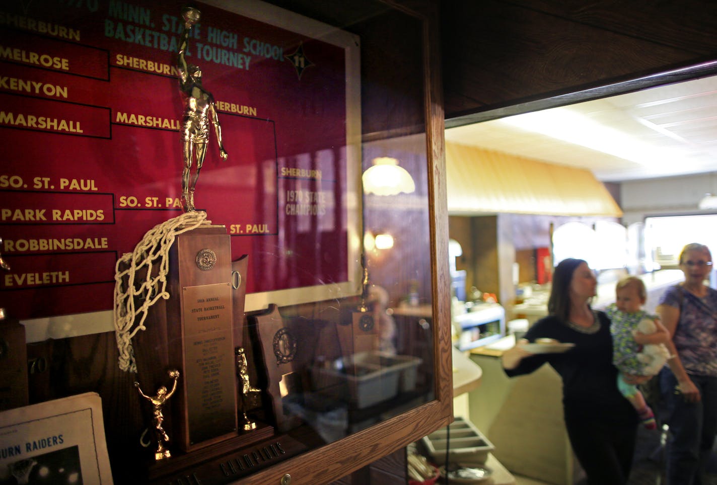 Twin Cities couple Seth and Elizabeth Lintelman won ownership of a Sherburn, Minn. cafe through a national essay writing contest. The Cup N' Saucer is the heart of Sherburn, and the new owners hope to continue that vibrancy. Here the Cup N' Saucer holds the trophy case for the pride of the Sherburn community, a first place trophy for boys high school basketball in 1970. ] BRIAN PETERSON &#x201a;&#xc4;&#xa2; brianp@startribune.com Sherburn, MN - 06/14/2013