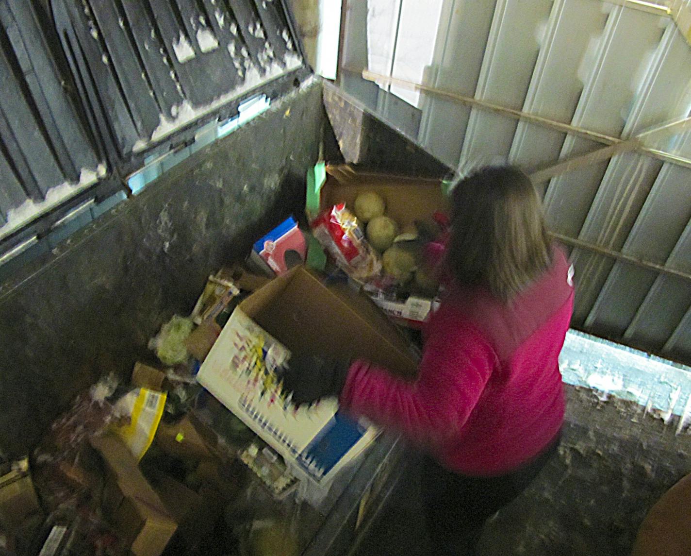 Dumpster-diving for edible food, location not identified,