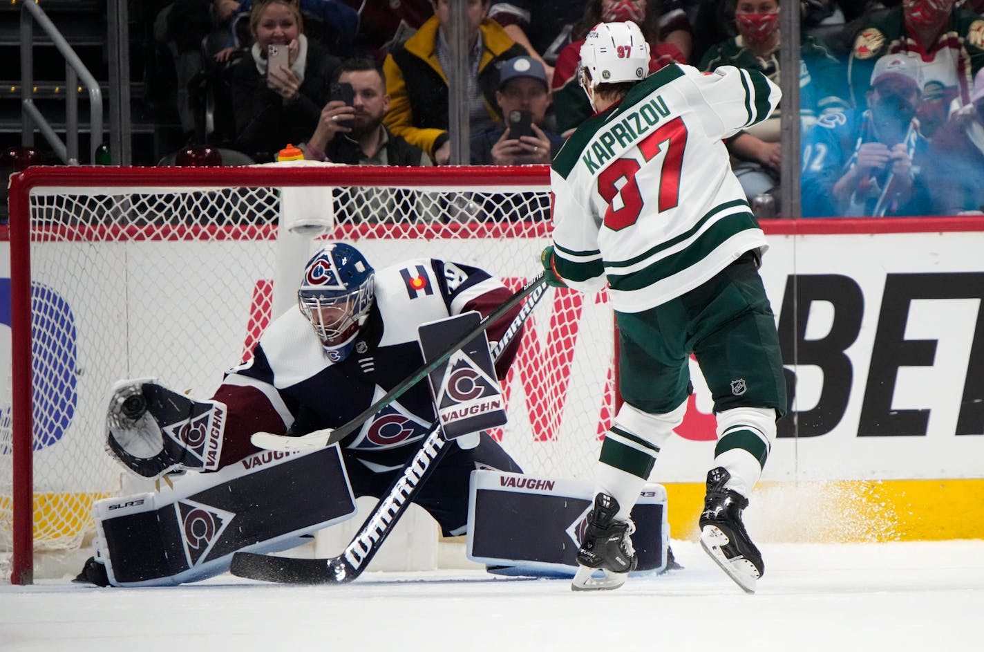 Colorado Avalanche goaltender Pavel Francouz, left, makes a glove-save of a shot off the stick of Minnesota Wild left wing Kirill Kaprizov, right, to end the shootout of an NHL hockey game Monday, Jan. 17, 2022, in Denver. (AP Photo/David Zalubowski)