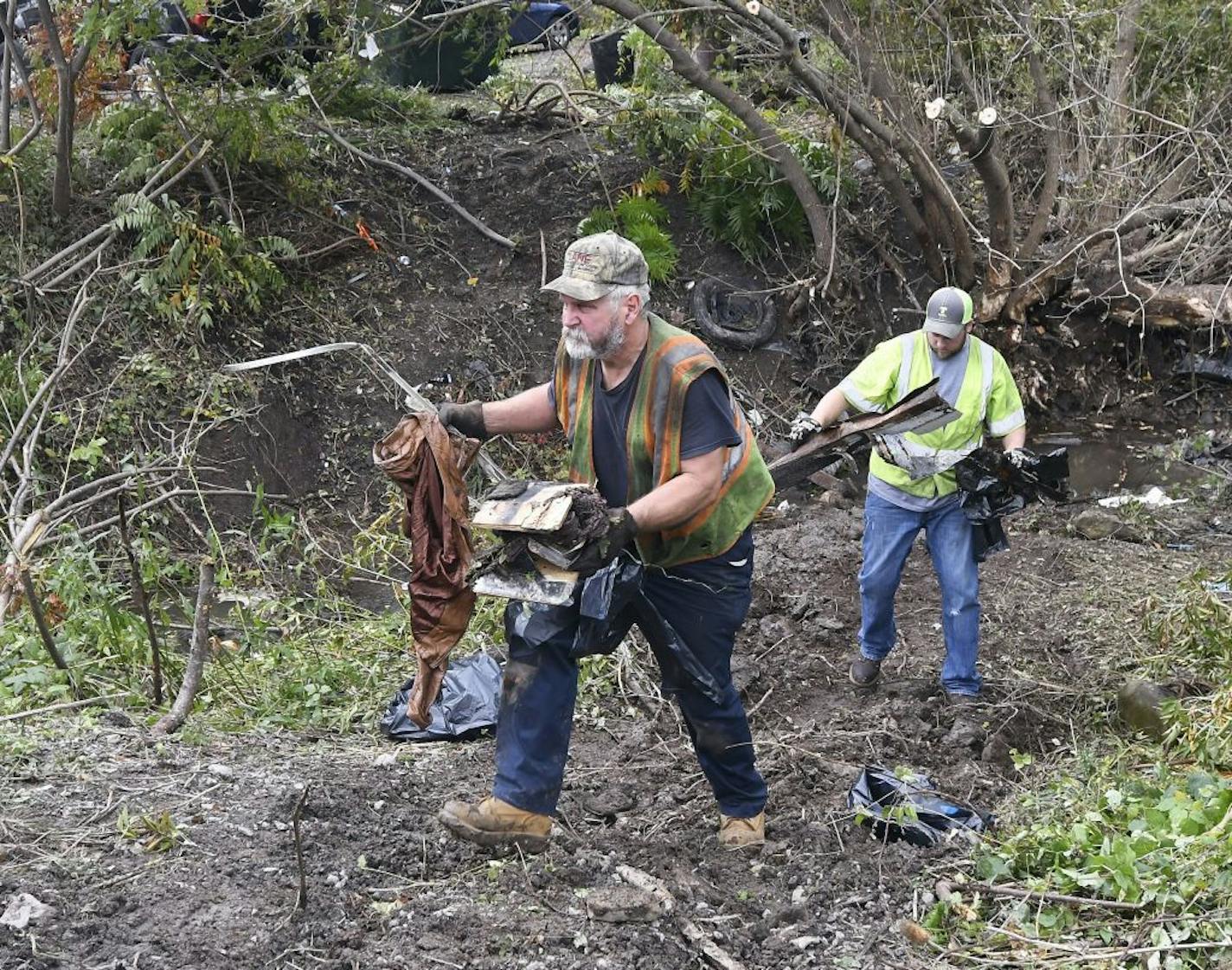 Recovery crews remove debris from the scene of a fatal crash, Sunday, Oct. 7, 2018, where a limousine crashed into a parked and unoccupied SUV killing 20 people at an intersection a day earlier, in Schoharie, N.Y.