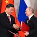 Russian President Vladimir Putin, right, and Chinese President Xi Jinping shake hands as they exchange documents during a signing ceremony following t