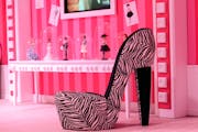 A chair in the shape of a high-heel is is displayed in the Barbie Dreamhouse Experience near Alexanderplatz square in Berlin, Germany,Thursday May 16,