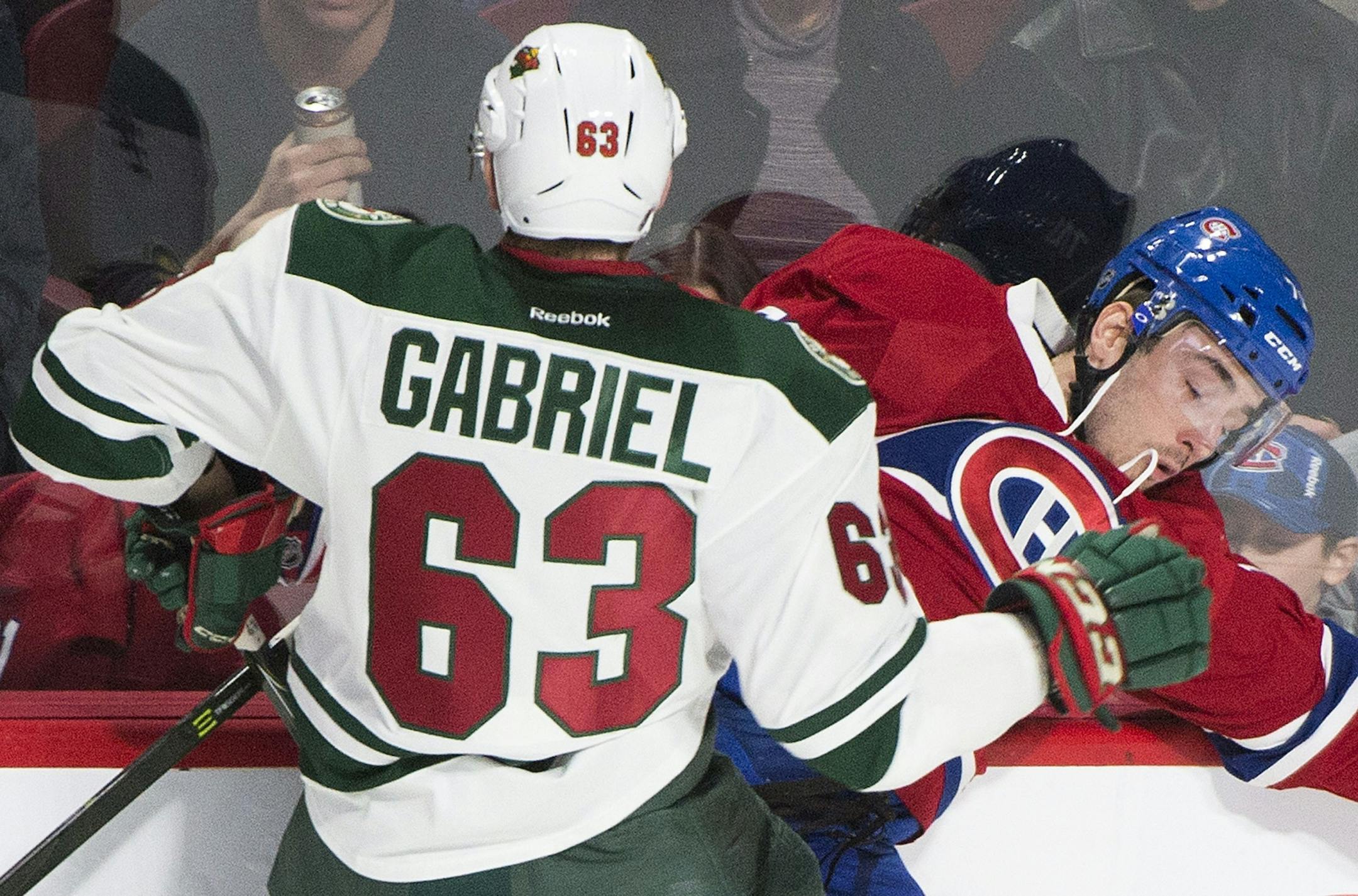Minnesota Wild's Kurtis Gabriel checks Montreal Canadiens' Joel Hanley during first-period NHL hockey game action in Montreal, Thursday, Dec. 22, 2016.