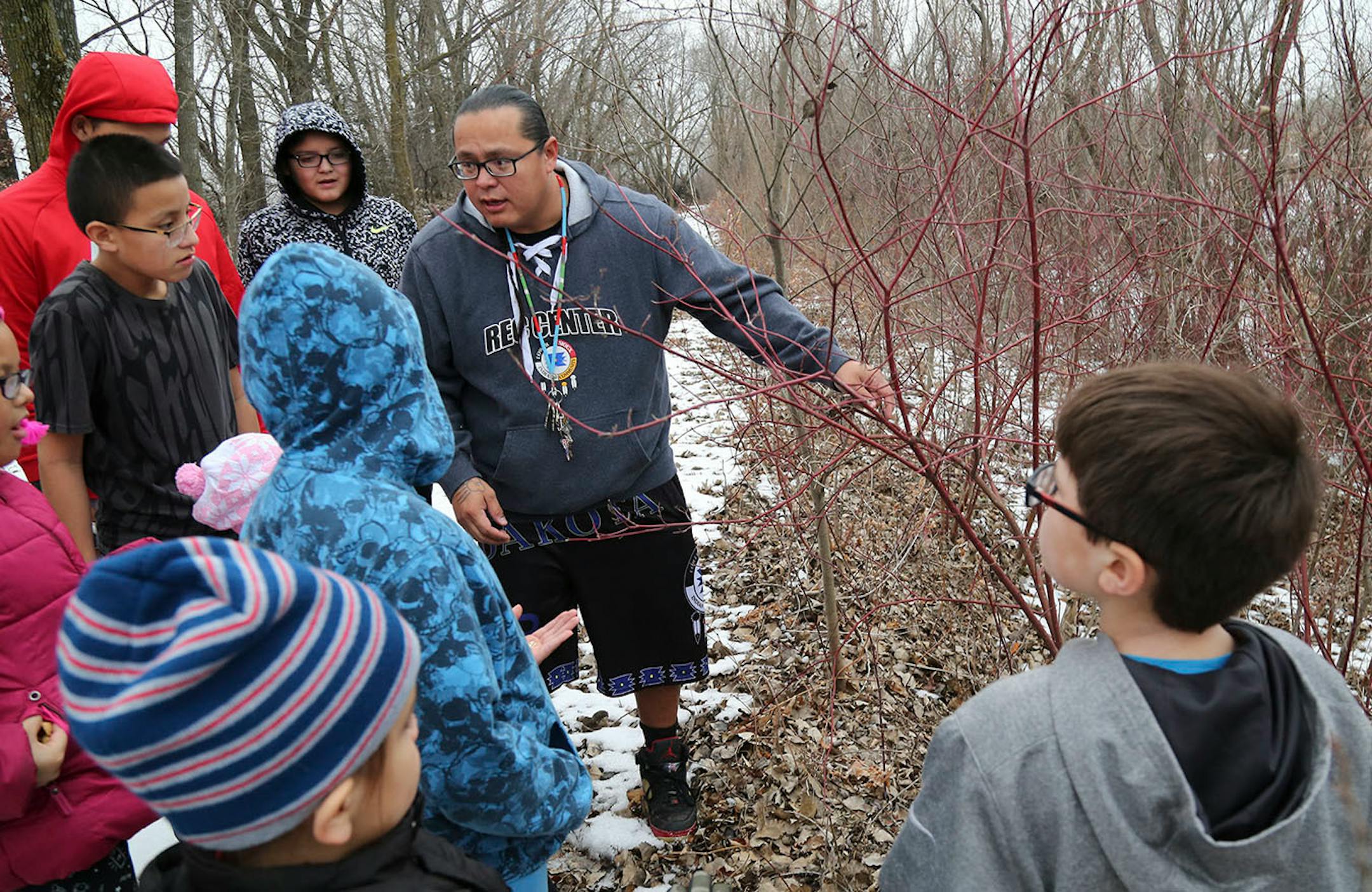 Teacher Mat Pendleton, who holds multiple positions with the Lower Sioux Community, explains to young community members how they will leave a tobacco offering near the trees before they begin to harvest any.