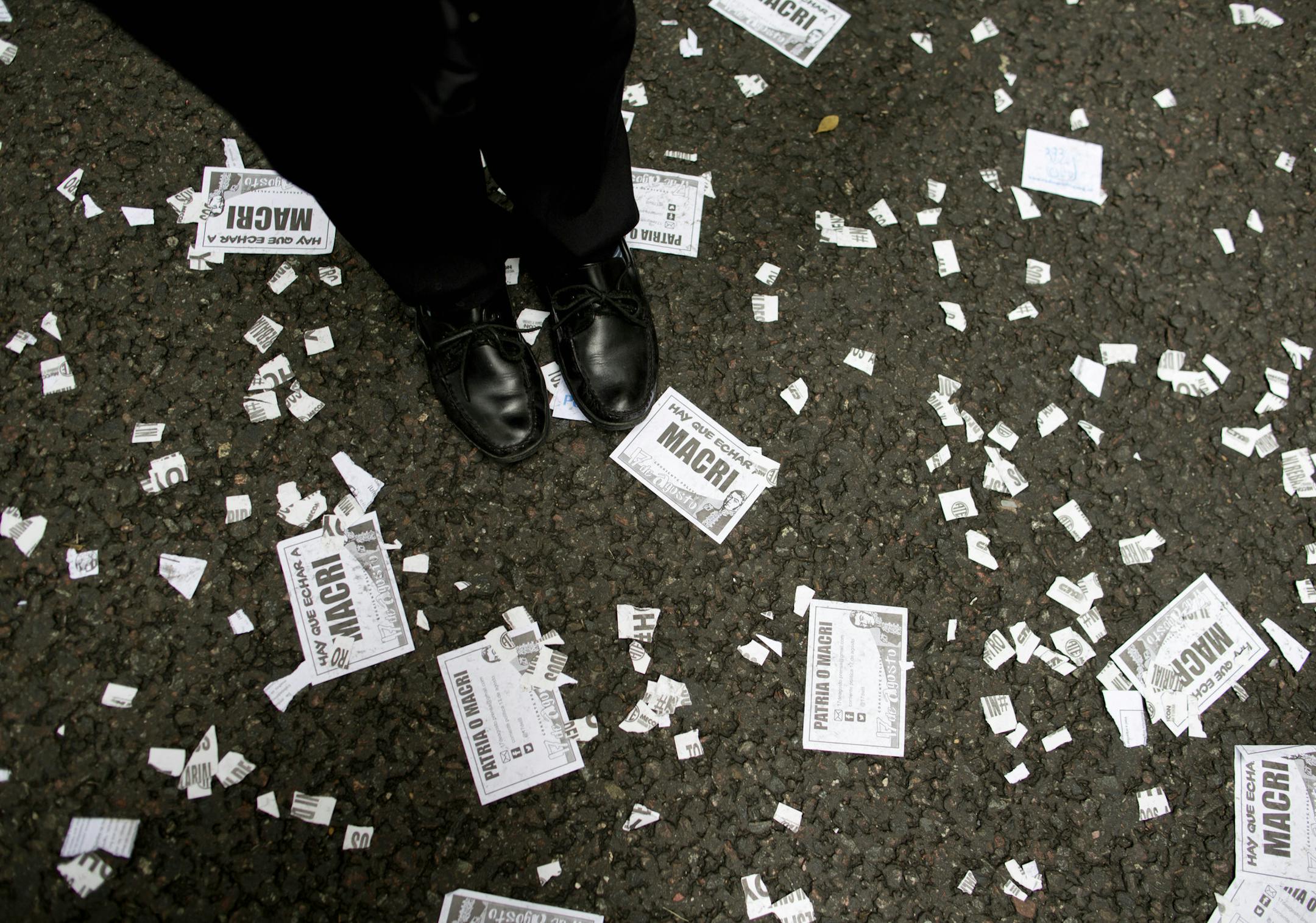 A worker demonstrates outside the Labor Ministry, standing on fliers that read in Spanish: "We have to fire Macri," referring to President Mauricio Macri, in Buenos Aires, Argentina, Wednesday, April 6, 2016. Ministry workers are on strike at every labor office across the country, demanding the immediate reinstatement of dismissed workers. (AP Photo/Natacha Pisarenko)
