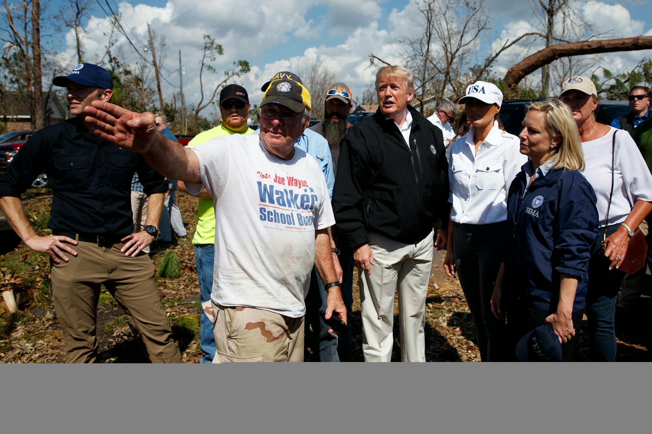 President Donald Trump and first lady Melania Trump tour a neighborhood affected by Hurricane Michael, Monday, Oct. 15, 2018, in Lynn Haven, Fla. Homeland Security Secretary Kirstjen Nielsen is front right.
