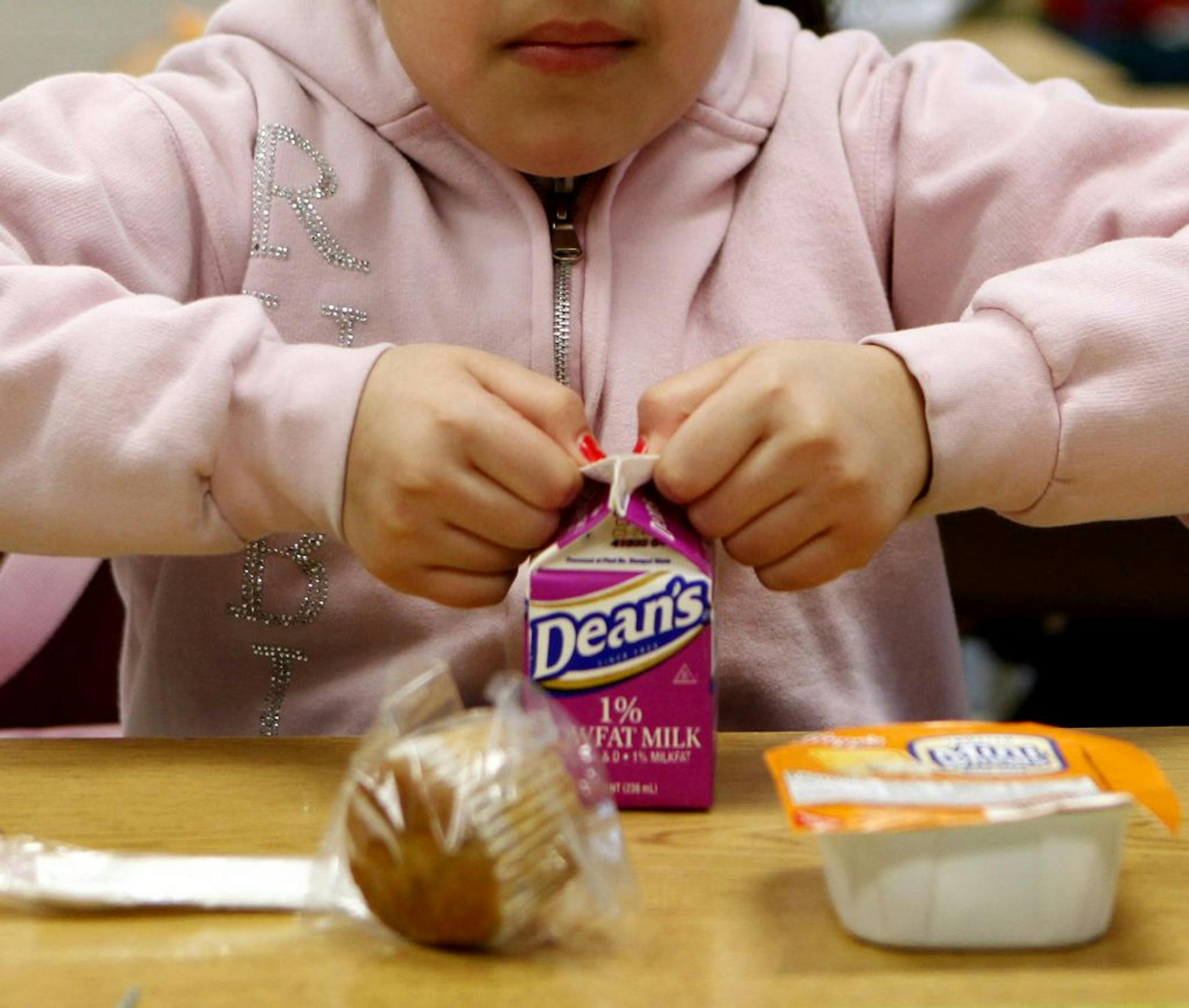 Clarissa Delgado opens a carton of milk to have with her cereal at McAuliffe Elementary School in Chicago, Illinois, in March 2011. Schools in the National School Lunch Program must offer milk and Chicago school officials require a note from a doctor stating a medical reason for a student to get a subsitute.