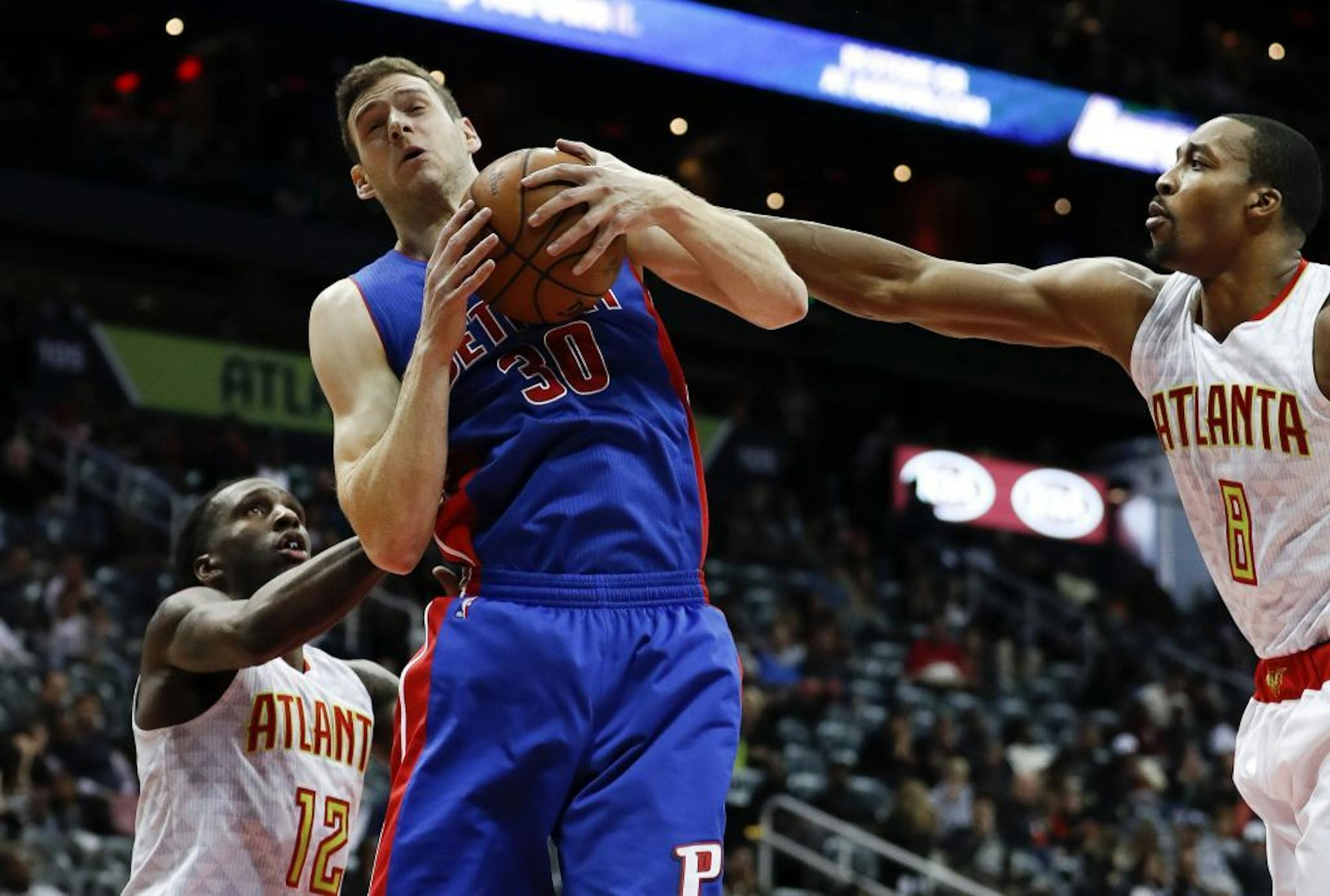 Detroit Pistons forward Jon Leuer (30) battles Atlanta Hawks center Dwight Howard (8) and forward Taurean Prince (12) as he drives to the basket in the second half of an NBA basketball game Friday, Dec. 2, 2016, in Atlanta.