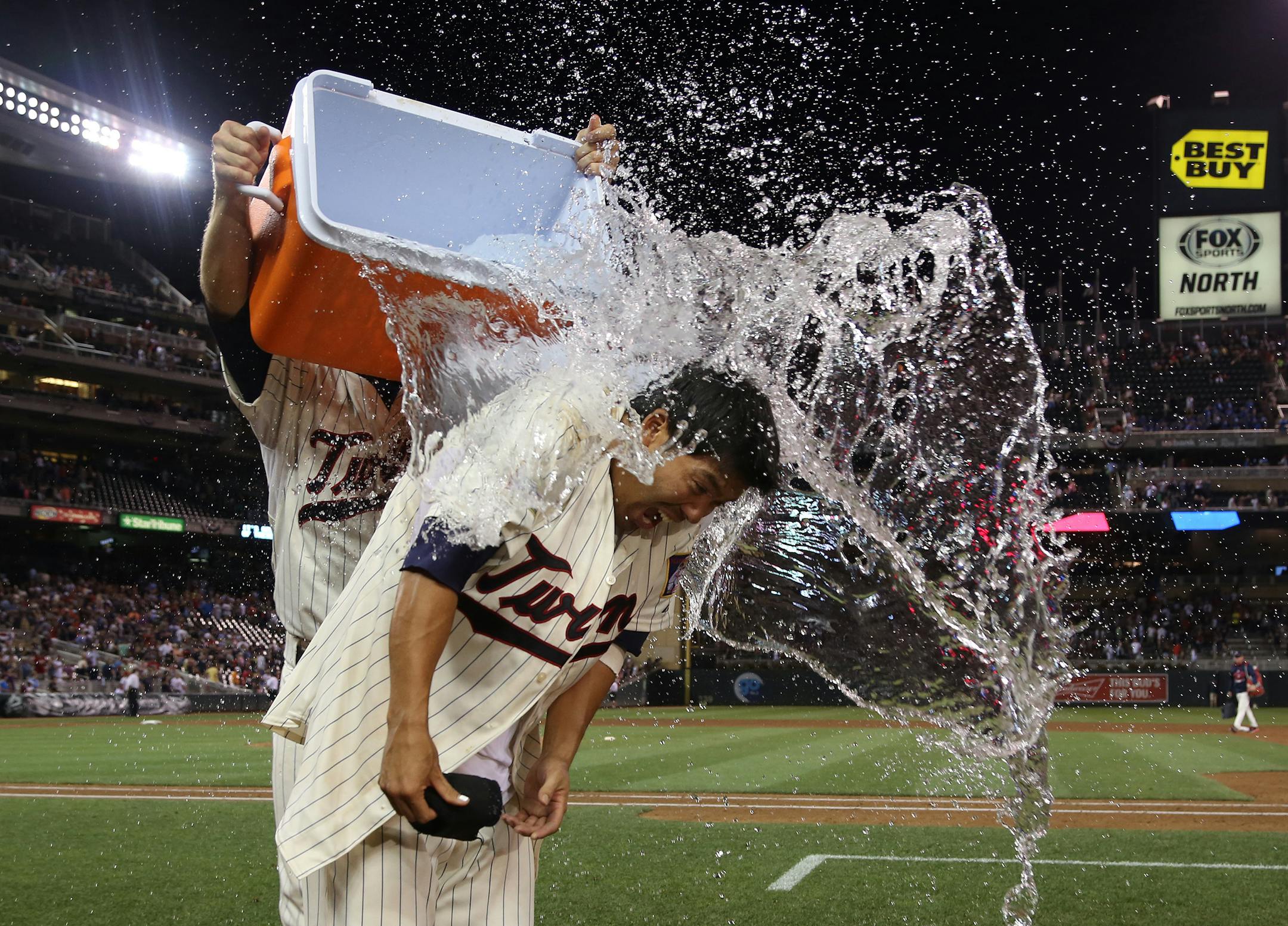 The Minnesota Twins' Kurt Suzuki is doused with water after driving in the winning run with a single in the ninth inning against the Seattle Mariners at Target Field in Minneapolis on Saturday, Aug. 1, 2015. The Twins won, 3-2. (Kyndell Harkness/Minneapolis Star Tribune/TNS) ORG XMIT: 1171733
