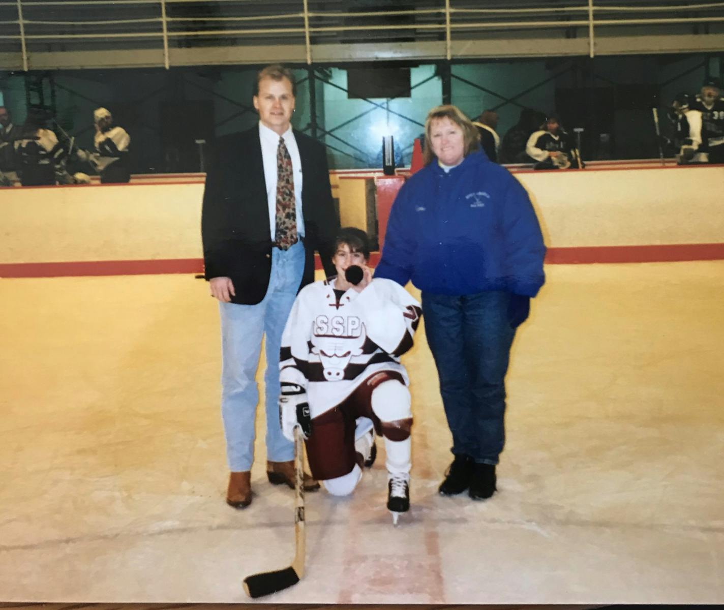 South St. Paul coach Dave Palmquist and Holy Angels coach Lynn Olson flanked Packers eighth-grade forward Kelly Kegley in a commemorative photo later that season. Kegley scored the first goal in Minnesota's first official high school girls' hockey game.