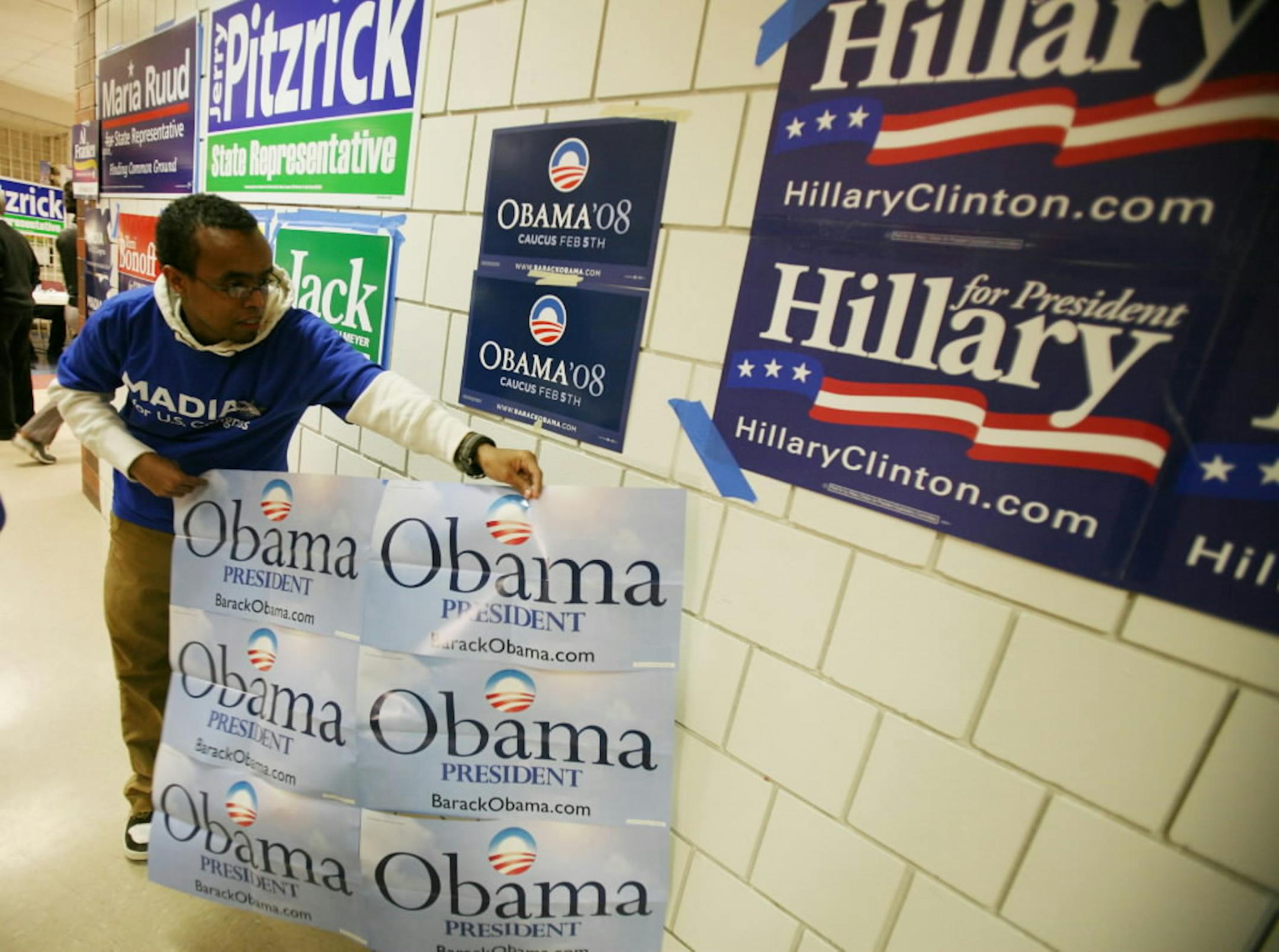 Ibrahim Waaeys 16, a student at Eden Prairie High School, placed a Barack Obama sign next to a Hillary Clinton sign at the school prior to Tuesday night's caucus.