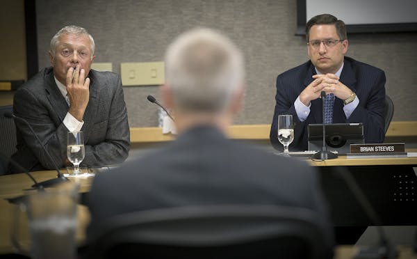 FILE -- University of Minnesota regent Steve Sviggum, left, and Brian Steeves, executive director of the regents board, listened during a regents meet