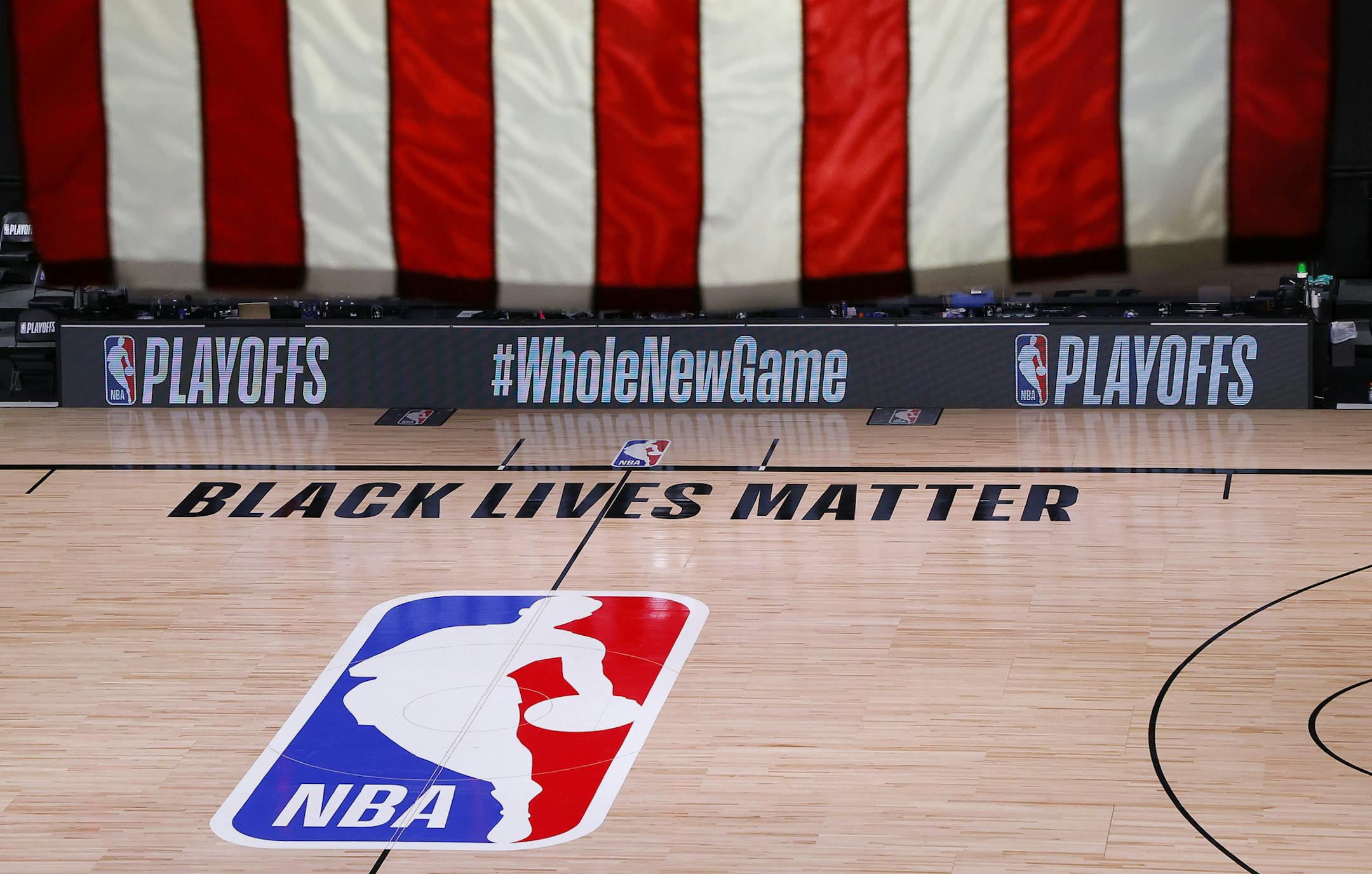 FILE - An empty court and bench are shown following the scheduled start time of Game 5 of an NBA basketball first-round playoff series, Wednesday, Aug. 26, 2020, in Lake Buena Vista, Fla. The NBA playoffs will resume Saturday after the league and the National Basketball Players Association detailed the commitments that made players comfortable continuing the postseason. In a joint statement released Friday, the sides say they will immediately establish a social justice coalition, made up of play
