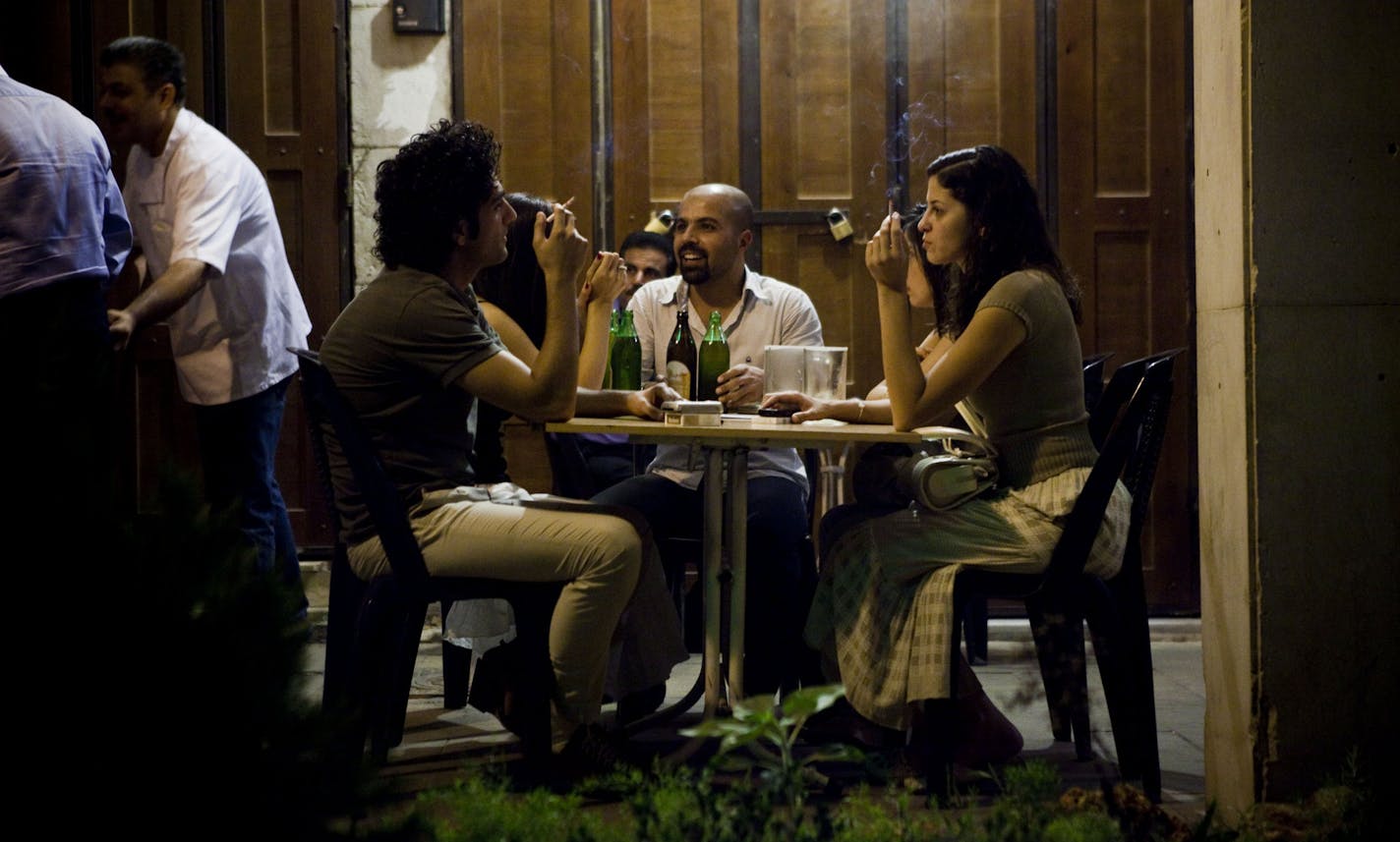 Young men and women drink and smoke at a bar in Damascus, Syria, on Aug. 10, 2010. Syria, which had sought to show solidarity with regional Islamic groups and allow religious figures a greater role in public life, has recently reversed course by curbing the Muslim conservative influence. (Bryan Denton/The New York Times) ORG XMIT: XNYT70