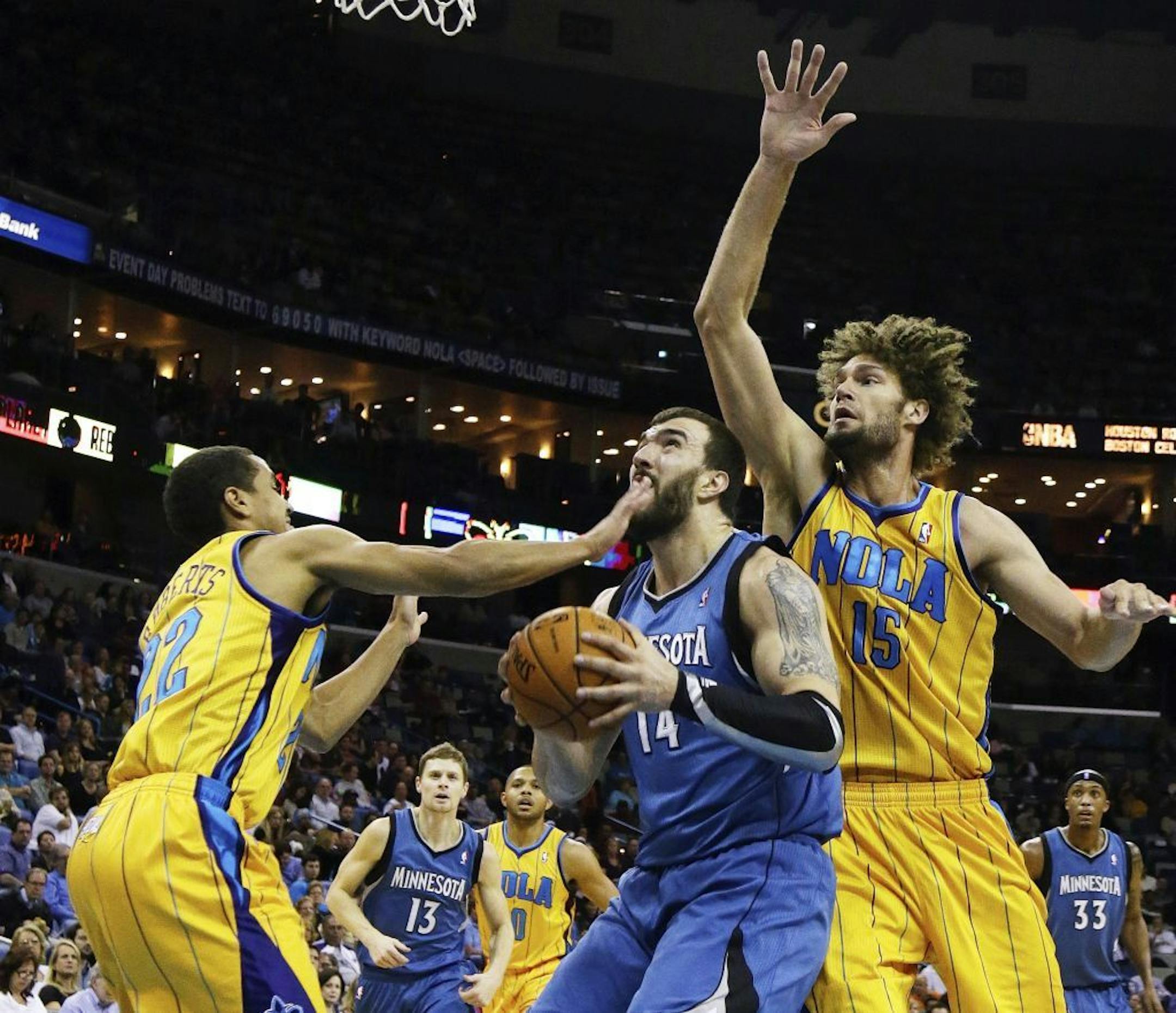 Hornets guard Brian Roberts (22) and center Brian Roberts (15) reached in on Timberwolves center Nikola Pekovic in the first half Friday.