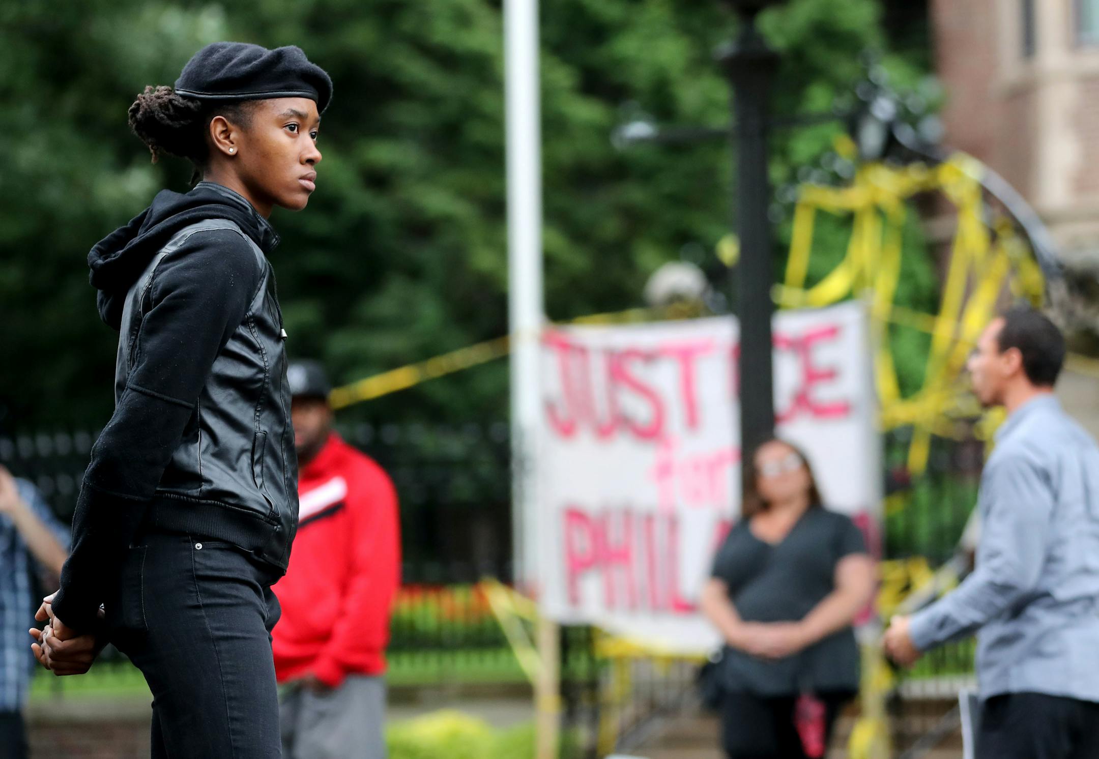 A woman who would not give her name stands guard outside Gov. Mark Dayton's mansion Thursday, July 7, 2016, during a protest in response to the shooting of Philando Castile, 32, a St. Paul schools employee, by a police officer following a traffic stop in Falcon Heights, MN. Castile later died Wednesday night at HCMC. "I'm here to serve and protect my people because the cops don't," she said.