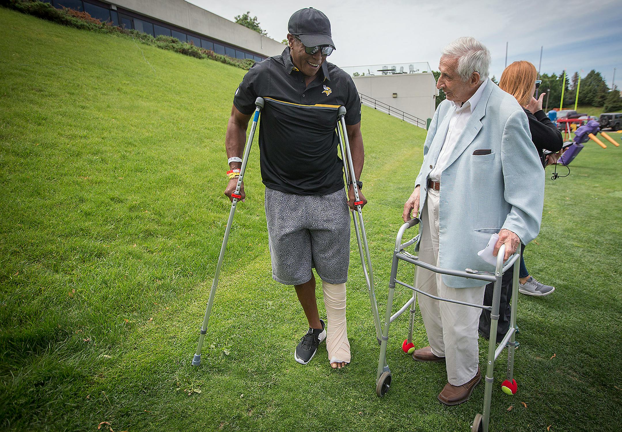 Legendary wide receiver Ahmad Rashad compared his crutches with Star Tribune's Sid Hartman's walker as they made their way to a press conference on the practice field at Winter Park, Wednesday, June 14, 2017 in Eden Prairie, MN.