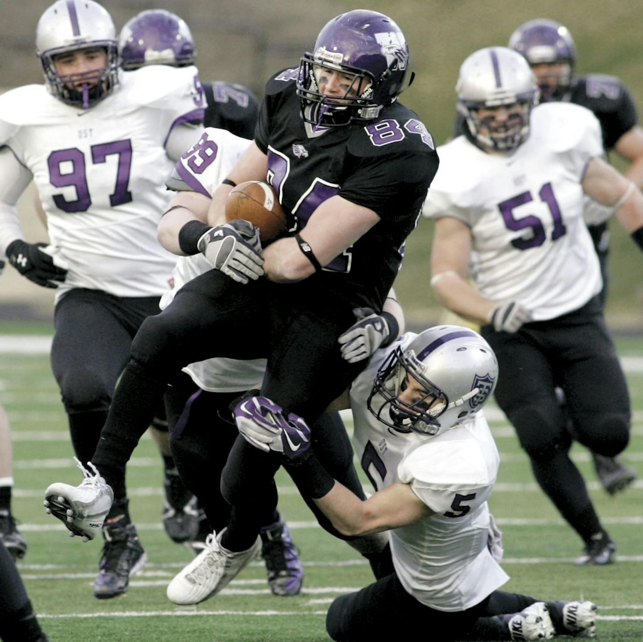 Wisconsin-Whitewater tight end Jason Ford (84) drafts St. Thomas defenders Tyler Erstad (5) and Danny Kane (99) during an NCAA Division III college football semifinal playoff game, Saturday, Dec. 10, 2011 in Whitewater, Wis.