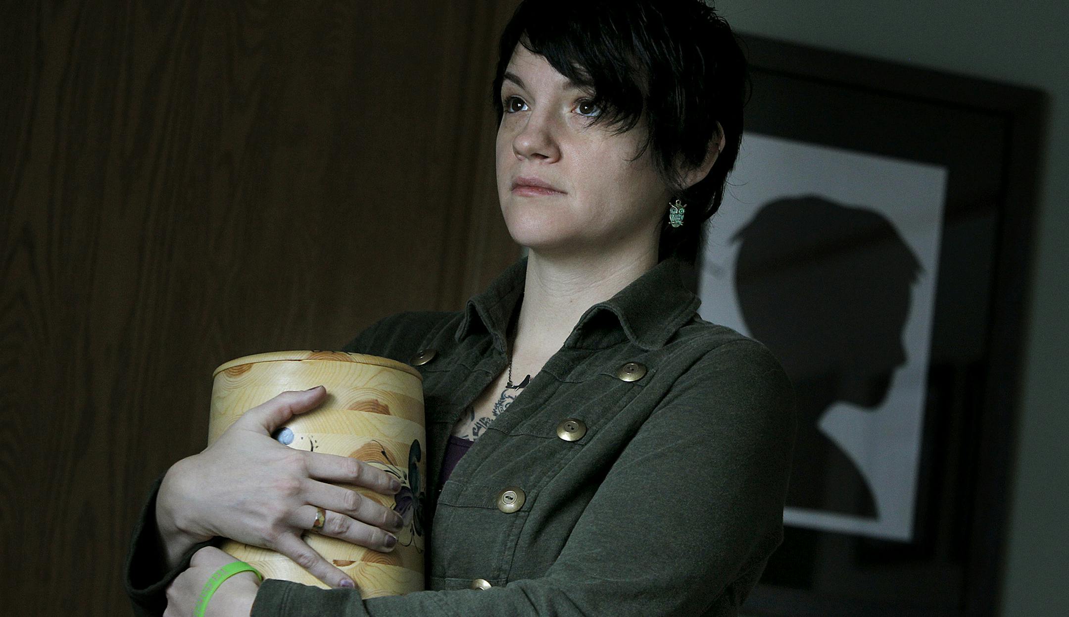 Jessica Schaffhausen held an urn holding some of the girls’ remains. Art by Sophie is in the background.