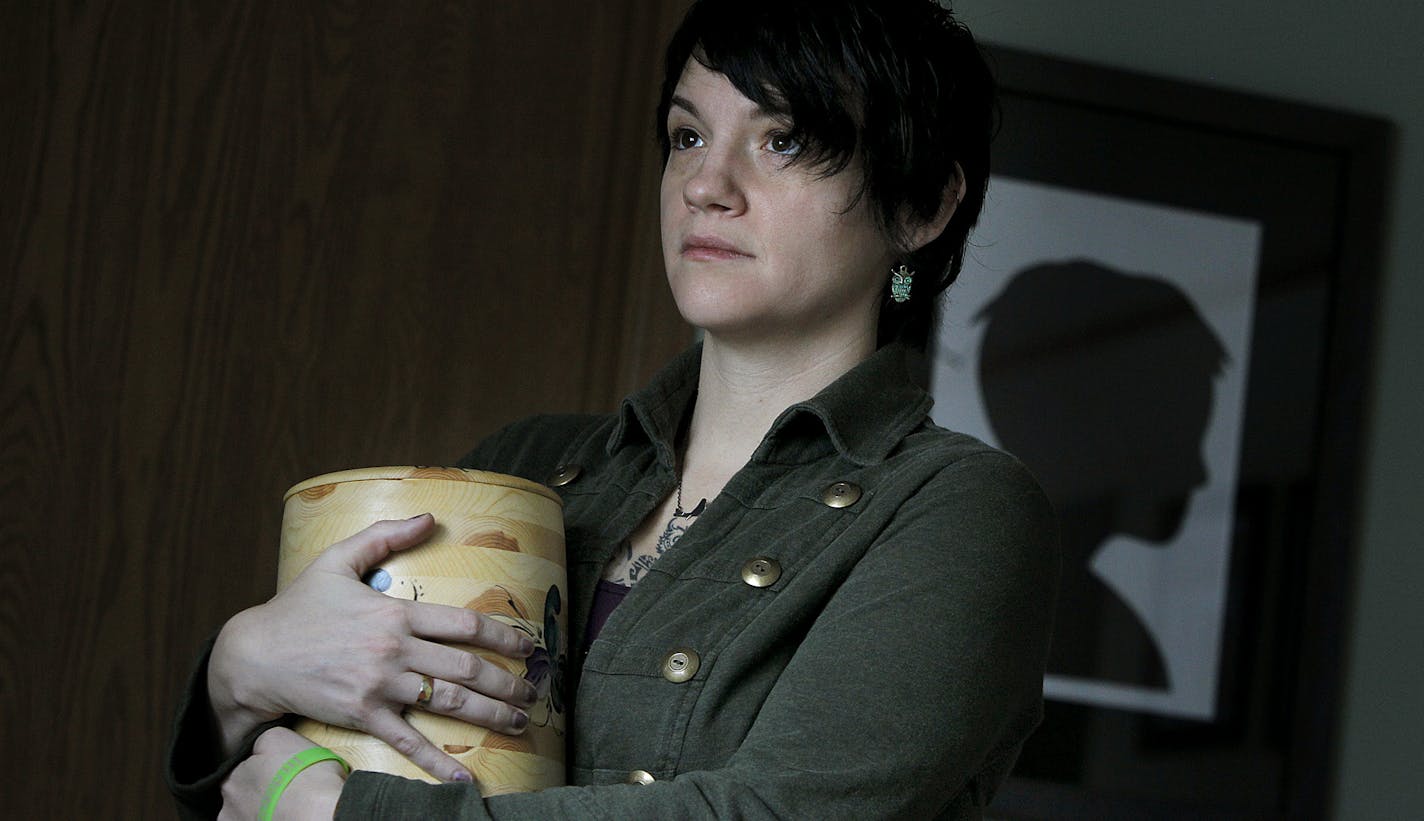 Jessica Schaffhausen held an urn holding some of the girls&#x2019; remains. Art by Sophie is in the background.