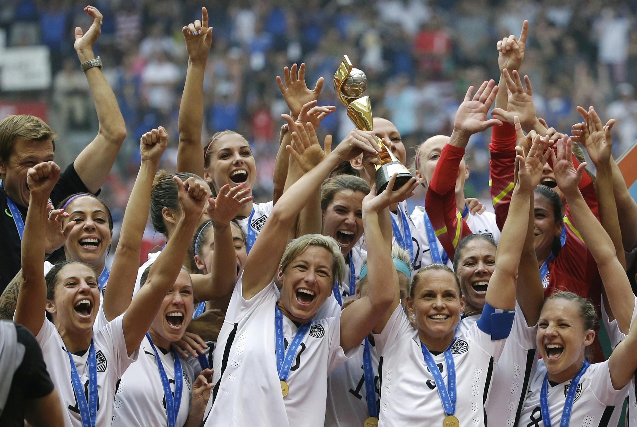 FILE - In this July 5, 2015, file photo, the United States Women's National Team celebrates with the trophy after they beat Japan 5-2 in the FIFA Women's World Cup soccer championship in Vancouver, British Columbia, Canada. Five players from the World Cup-winning U.S. national team have accused the U.S. Soccer Federation of wage discrimination in an action filed with the Equal Employment Opportunity Commission. Alex Morgan, Carli Lloyd, Megan Rapinoe, Becky Sauerbrunn and Hope Solo maintain in t