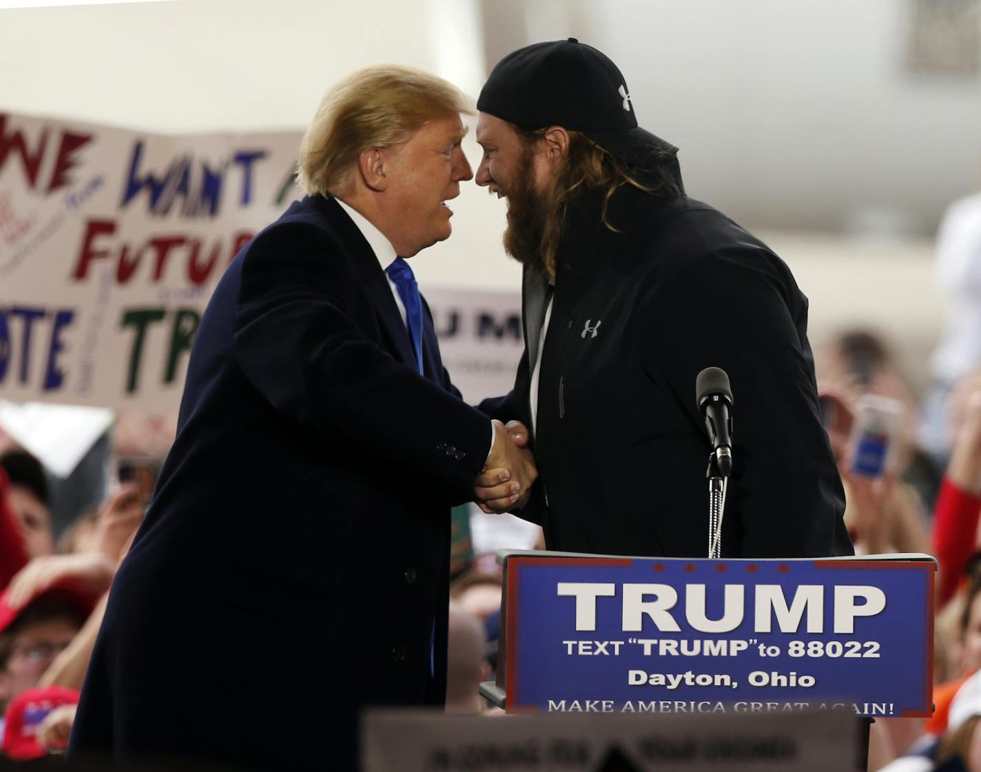 Republican presidential candidate Donald Trump shakes hands with former Ohio State and NFL football player Nick Mangold as he arrives at the Wright Brothers Aero Hangar for a rally, Saturday, March 12, 2016, in Vandalia, Ohio. (AP Photo/Kiichiro Sato)