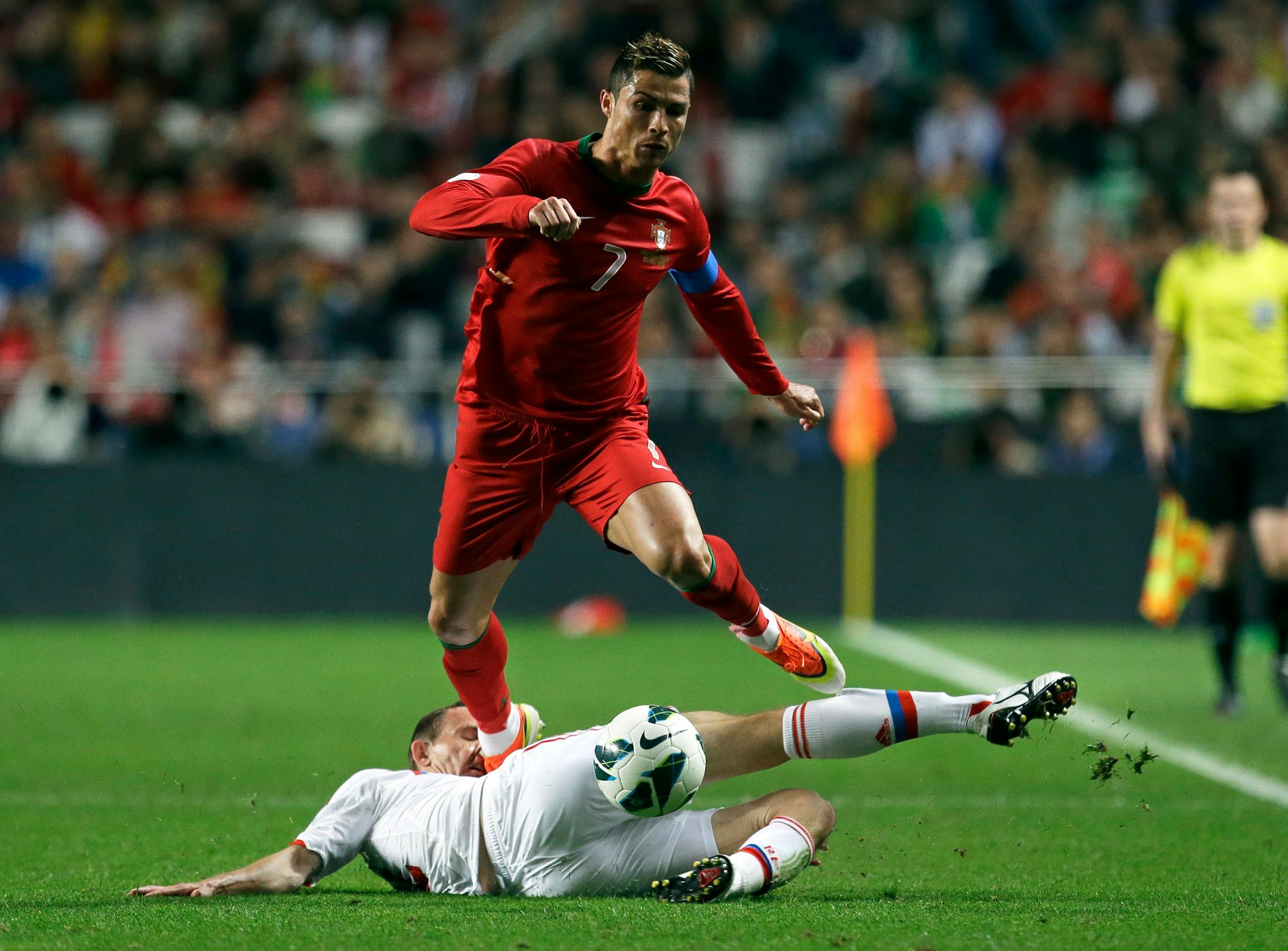 FILE - In this June 7, 2013, file photo, Portugal's Cristiano Ronaldo gets the ball past Russia's Alexei Kozlov.