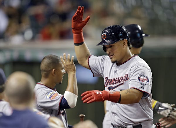 Minnesota Twins' Oswaldo Arcia celebrates at the dugout after a two-run home run off Cleveland Indians starting pitcher Trevor Bauer in the fourth inn