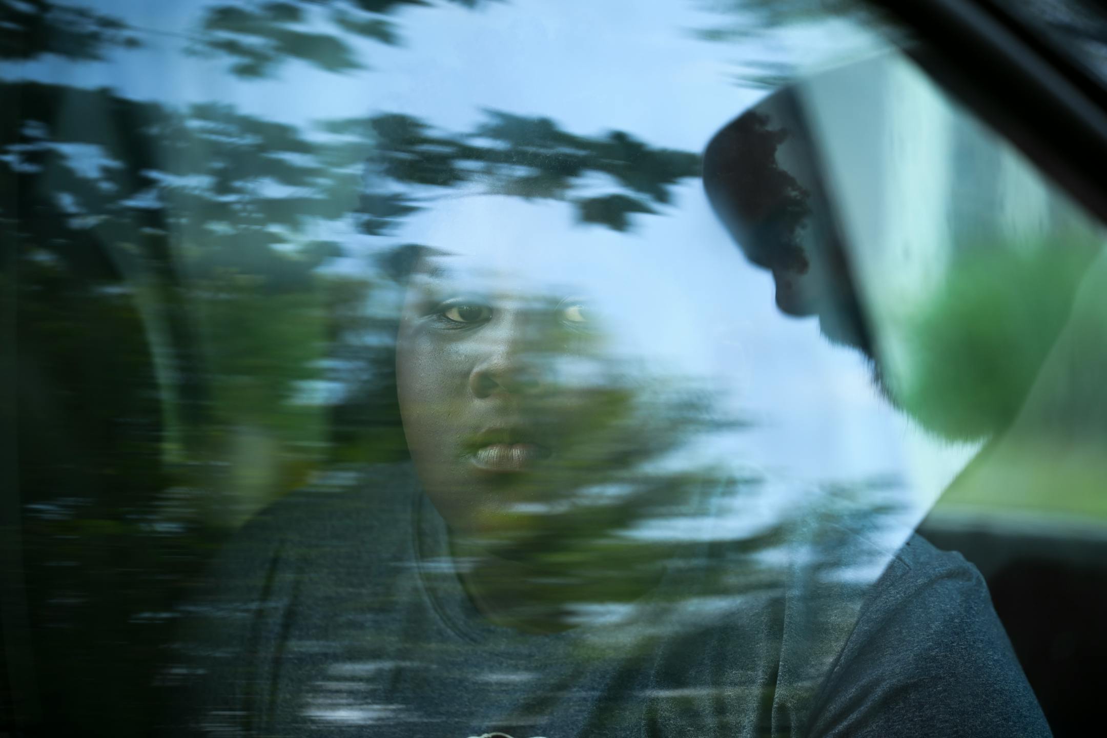 C.J. Johnson, 10, sits in a car before practice at Bryn Mawr Meadows Park in Minneapolis. Johnson says he was at the practice interrupted by gunfire three years ago.