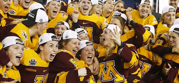 Minnesota players celebrate with the trophy after defeating Boston College 3-1 in the women's Frozen Four championship college hockey game in Durham, 