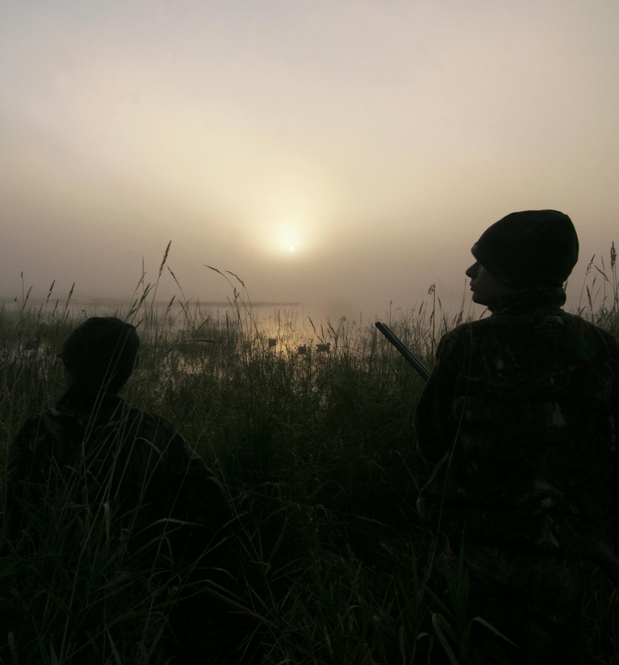 Doug Smith/Star Tribune; Sept. 13, 2014; Emily Schmidtbauer (left) and her twin brother, Joseph, both 12, of Brooklyn Park, scan a foggy sky for ducks at dawn Saturday on Minnesota's Youth Waterfowl Day. The special one-day waterfowl hunt is for youths 15 and under.