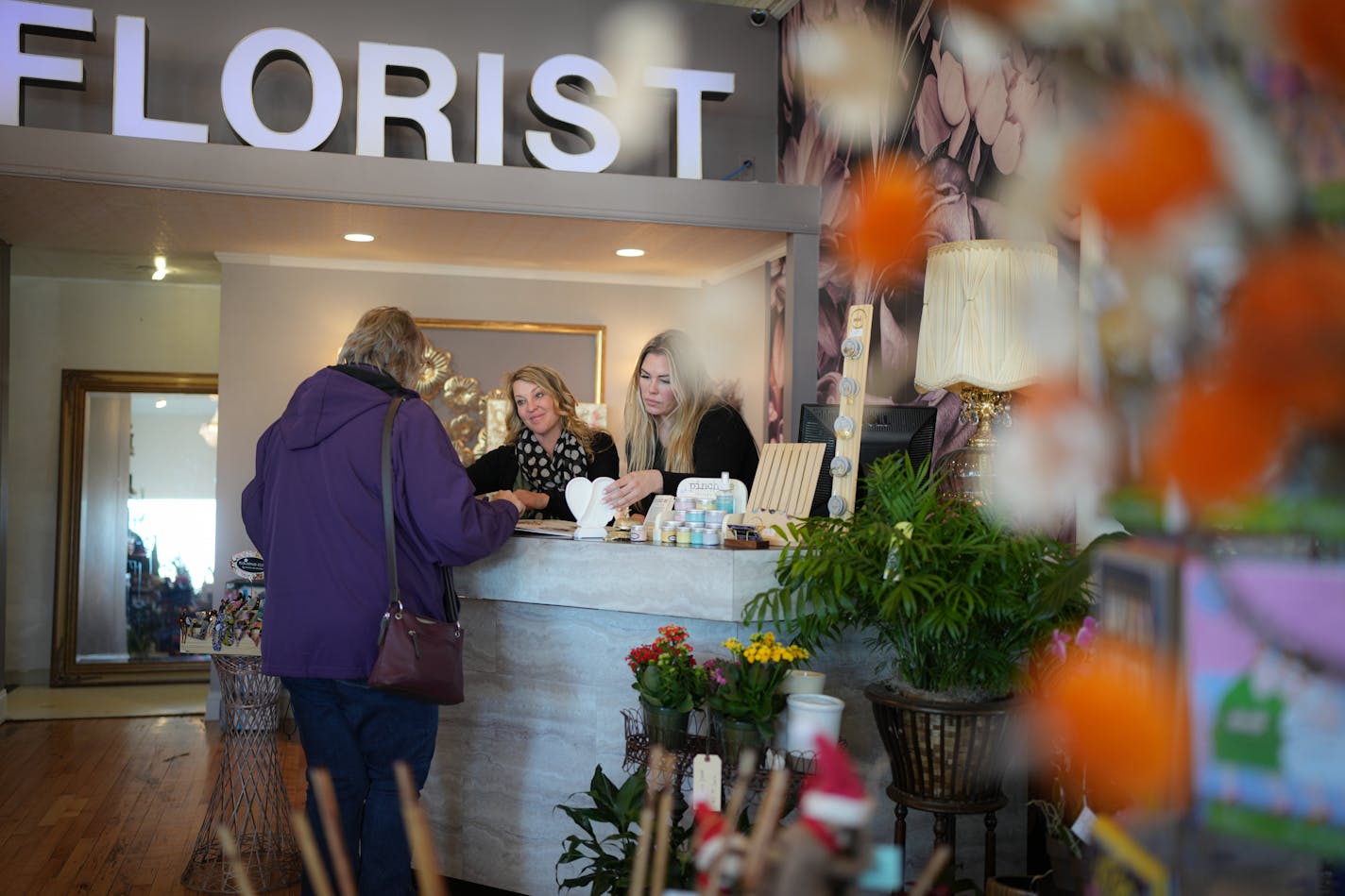 Kelly Vranicar and Erika Kensinger helped a customer at Rosemount Floral by Lucky Lola in downtown Rosemount on Friday.